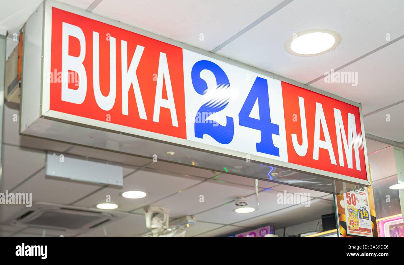 Un cartello per KK Super Mart (o KK Supermart) il cartello recita "BUKA 24 JAM", "aperto 24 ore su 24". , Kuala Lumpur, Malesia Foto Stock