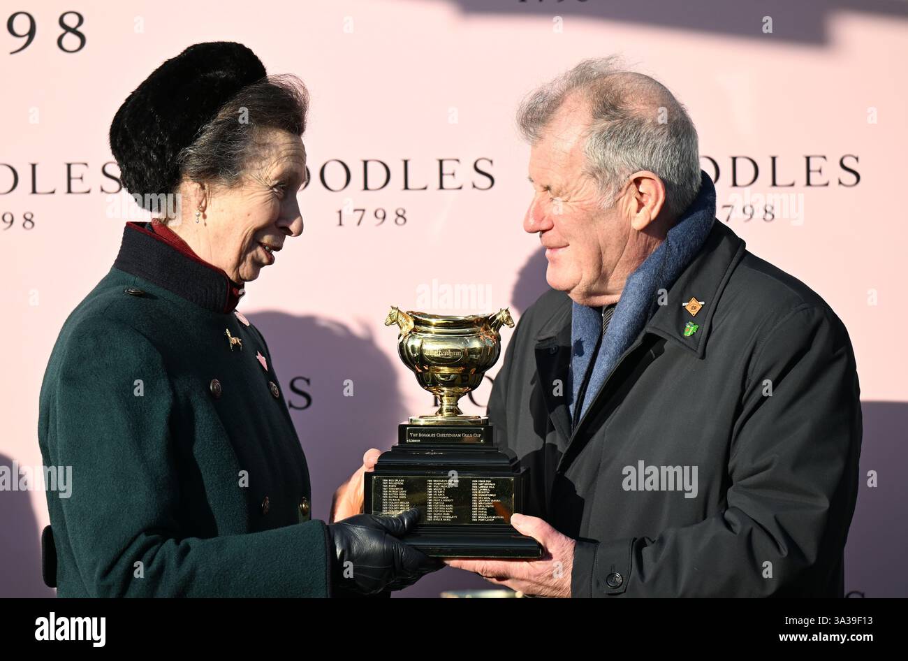 14 marzo 2025; Cheltenham Racecourse, Cheltenham, Gloucestershire, Inghilterra: 2025 Cheltenham Festival Day 4; HRH Princess Anne presenta la Gold Cup a JP McManus, proprietario di Inothewayurthinkin dopo aver vinto il Boodles Cheltenham Gold Cup Chase Foto Stock