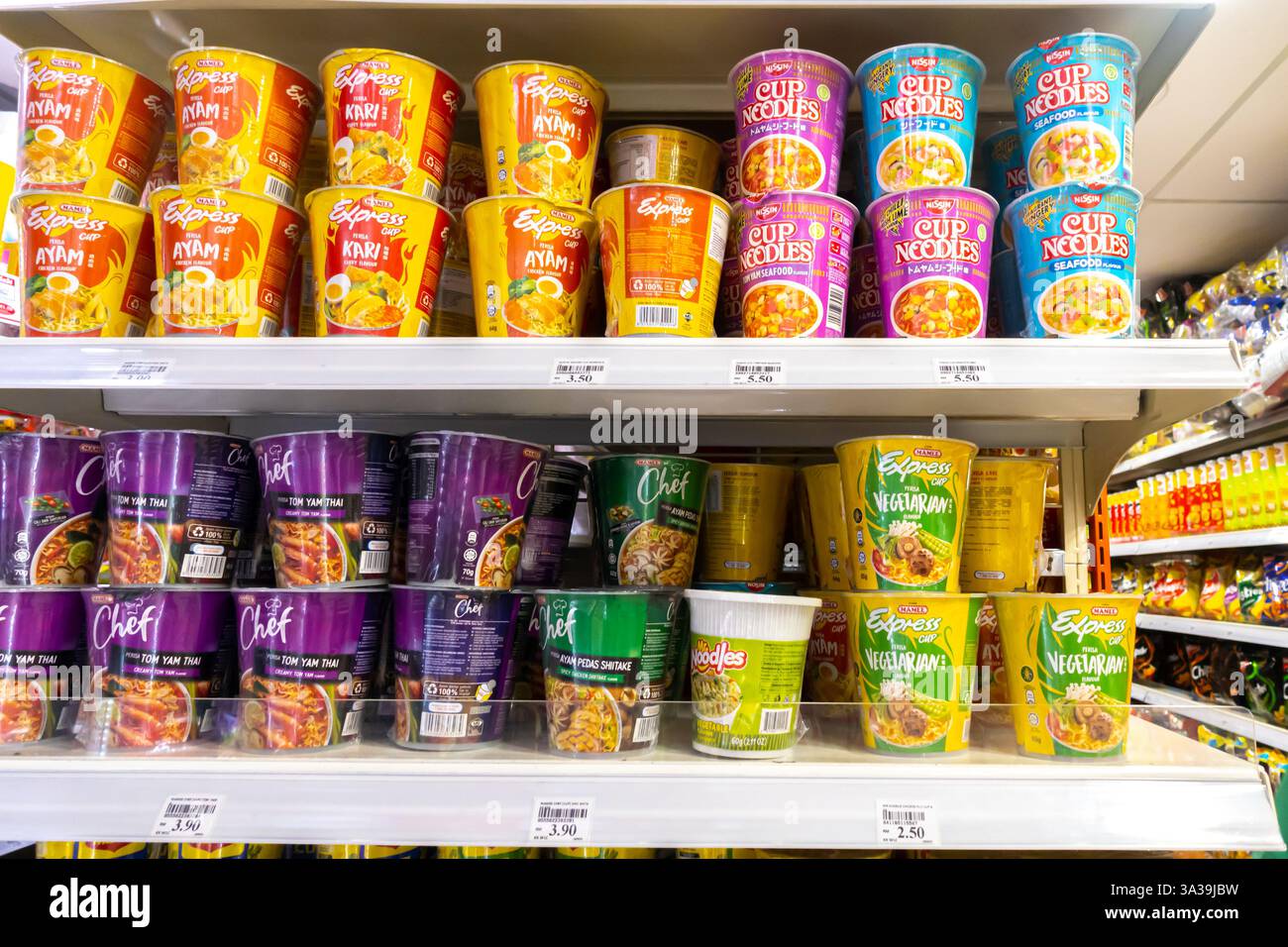 Scaffali riforniti con varie marche di spaghetti istantanei, prevalentemente Maggi, in un KK Mart di Kuala Lumpur. spaghetti istantanei a tazza o a tazza Foto Stock