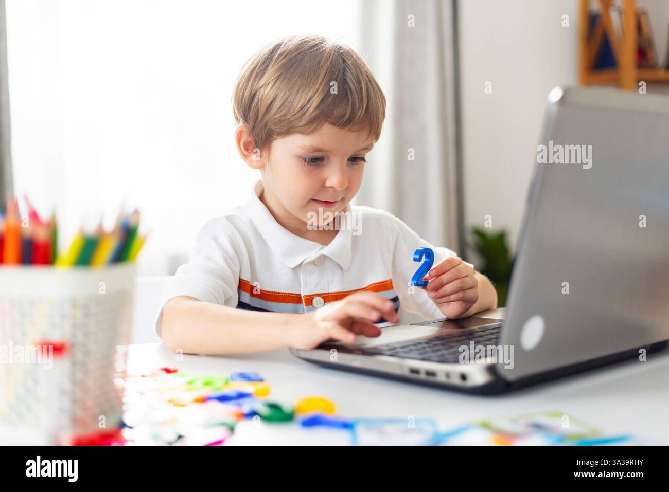 Bambini che imparano online con un notebook a casa Foto Stock