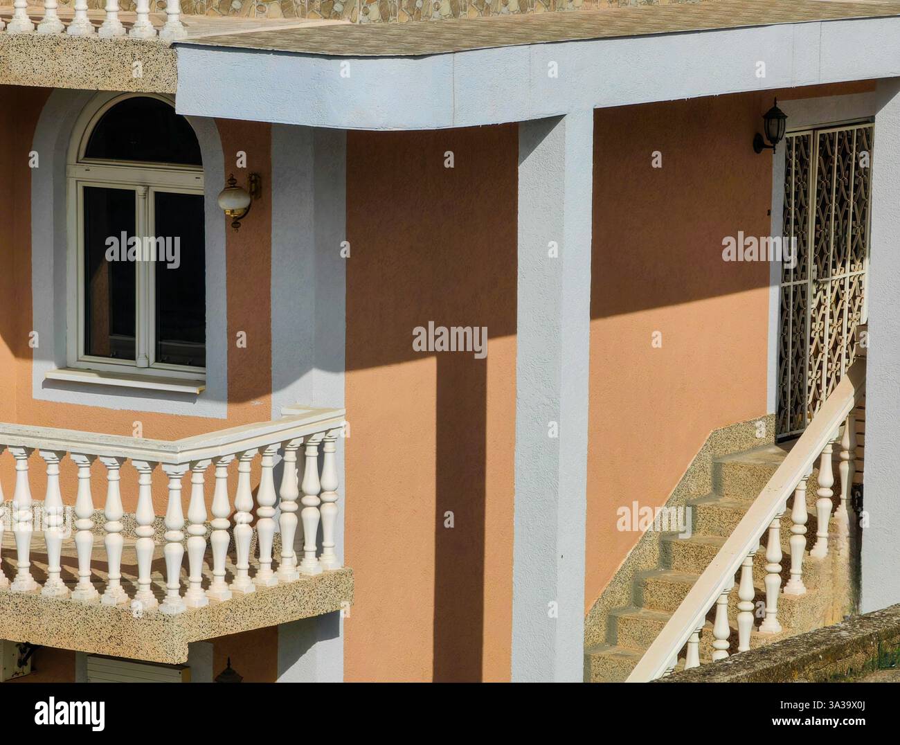 Armonia mattutina: Muro arancione e colonne bianche Foto Stock