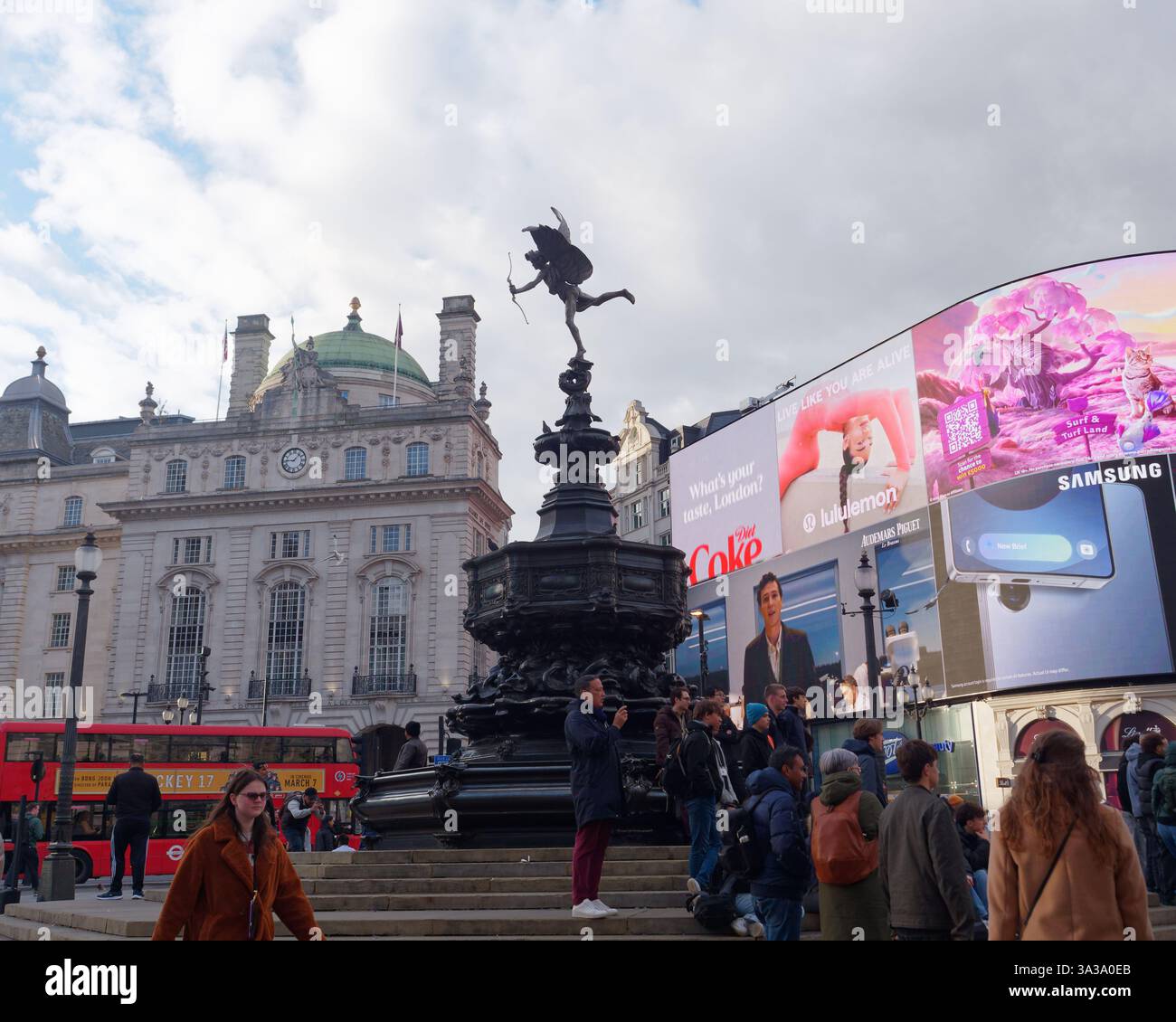 La Shaftesbury Memorial Fountain, alias Eros a Piccadilly Circus, con schermo iconico, edificio, London Bus e folle a Londra, marzo 2025 Foto Stock
