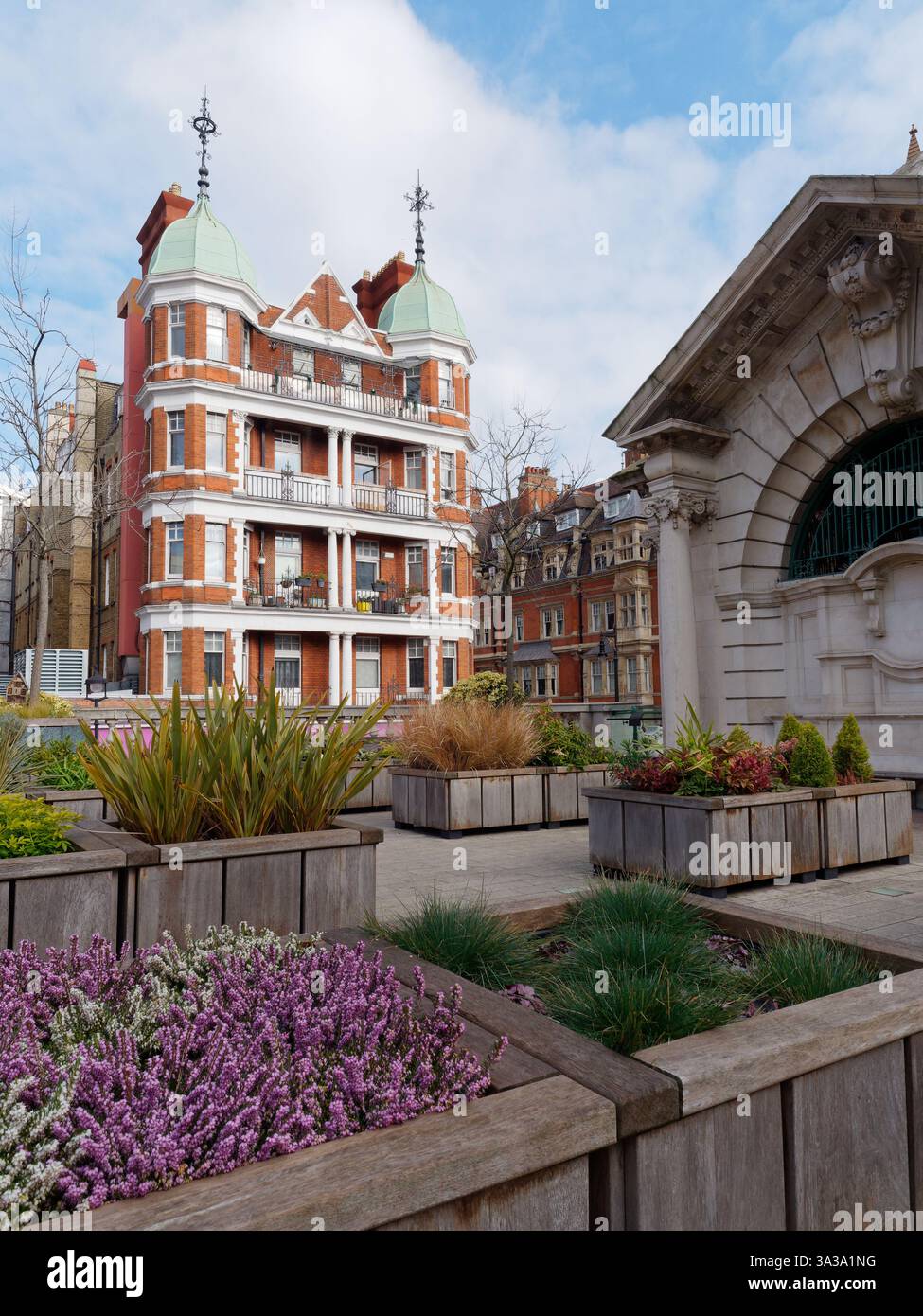 Brown Hart Gardens, un pittoresco giardino con aiuole di fiori e posti a sedere sollevati al di sopra del livello della strada circondato dall'architettura di Mayfair, Londra, marzo 2025 Foto Stock