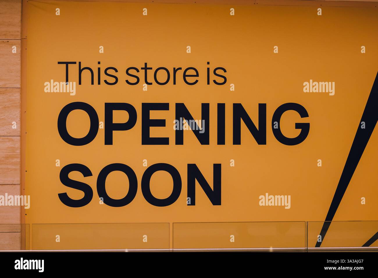 Pannello con il testo "questo negozio APRIRÀ PRESTO" in lettere nere. La fotografia è scattata in stile moderno con angoli dritti e linee pulite 0 Foto Stock