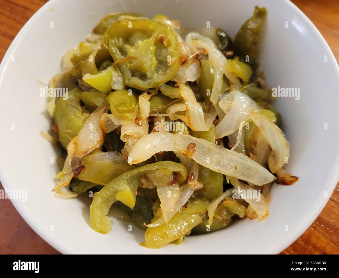 Habanero o Gendot Chilli Peppers fritti con cipolle in una ciotola bianca. Foto Stock