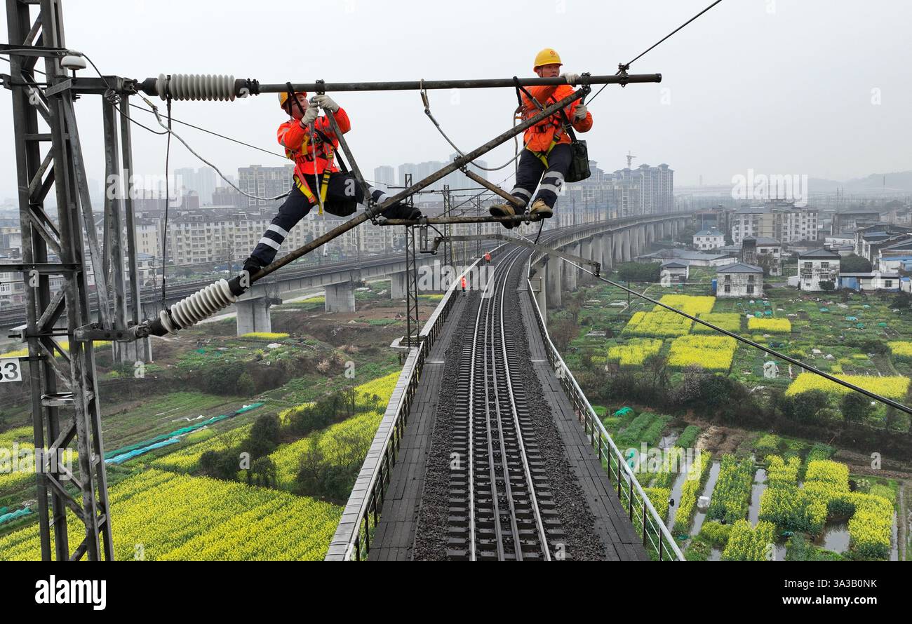 NANCHANG, CINA - 14 MARZO 2025 - due lavoratori della linea aerea di contatto presso un'officina di alimentazione revisionano le apparecchiature della linea aerea di contatto presso Lushan Foto Stock
