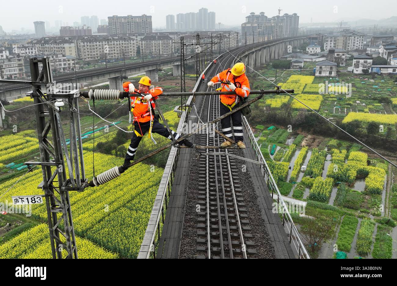 NANCHANG, CINA - 14 MARZO 2025 - due lavoratori della linea aerea di contatto presso un'officina di alimentazione revisionano le apparecchiature della linea aerea di contatto presso Lushan Foto Stock