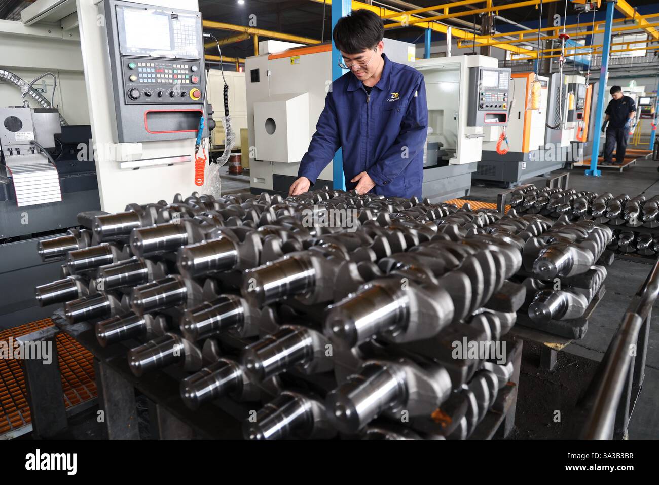 BINZHOU, CINA - 14 MARZO 2025 - Un lavoratore produce prodotti per albero motore presso un'officina di un produttore di parti motore a Binzhou, nella Cina orientale Shandon Foto Stock