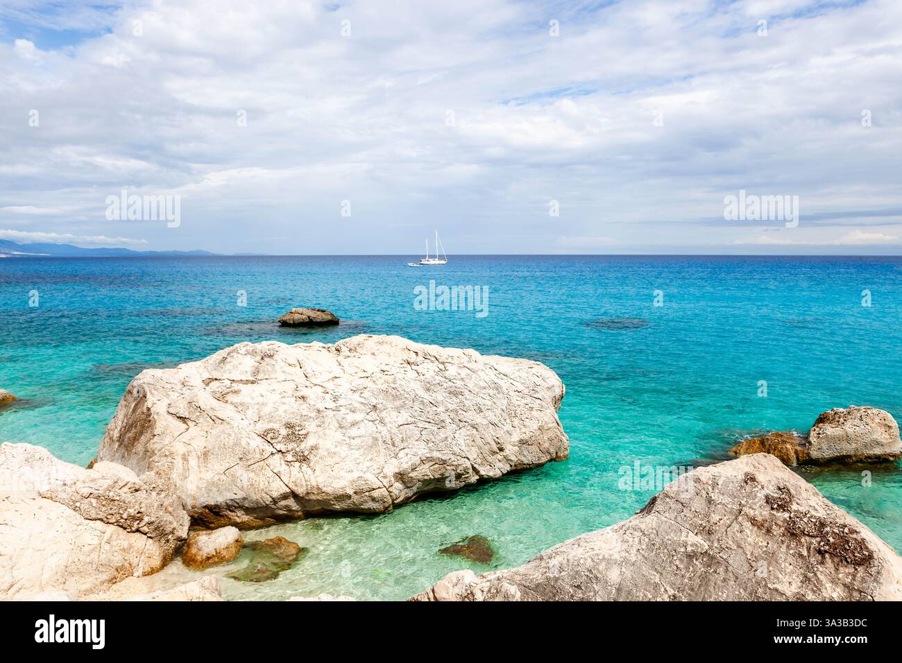 Meravigliosa acqua turchese color smeraldo del Mar Tirreno, Sardegna, Italia. Rocce meravigliose e barca a vela bianca. Spiaggia Cala Goloritze, zona Baunei, Sardegna. Foto Stock