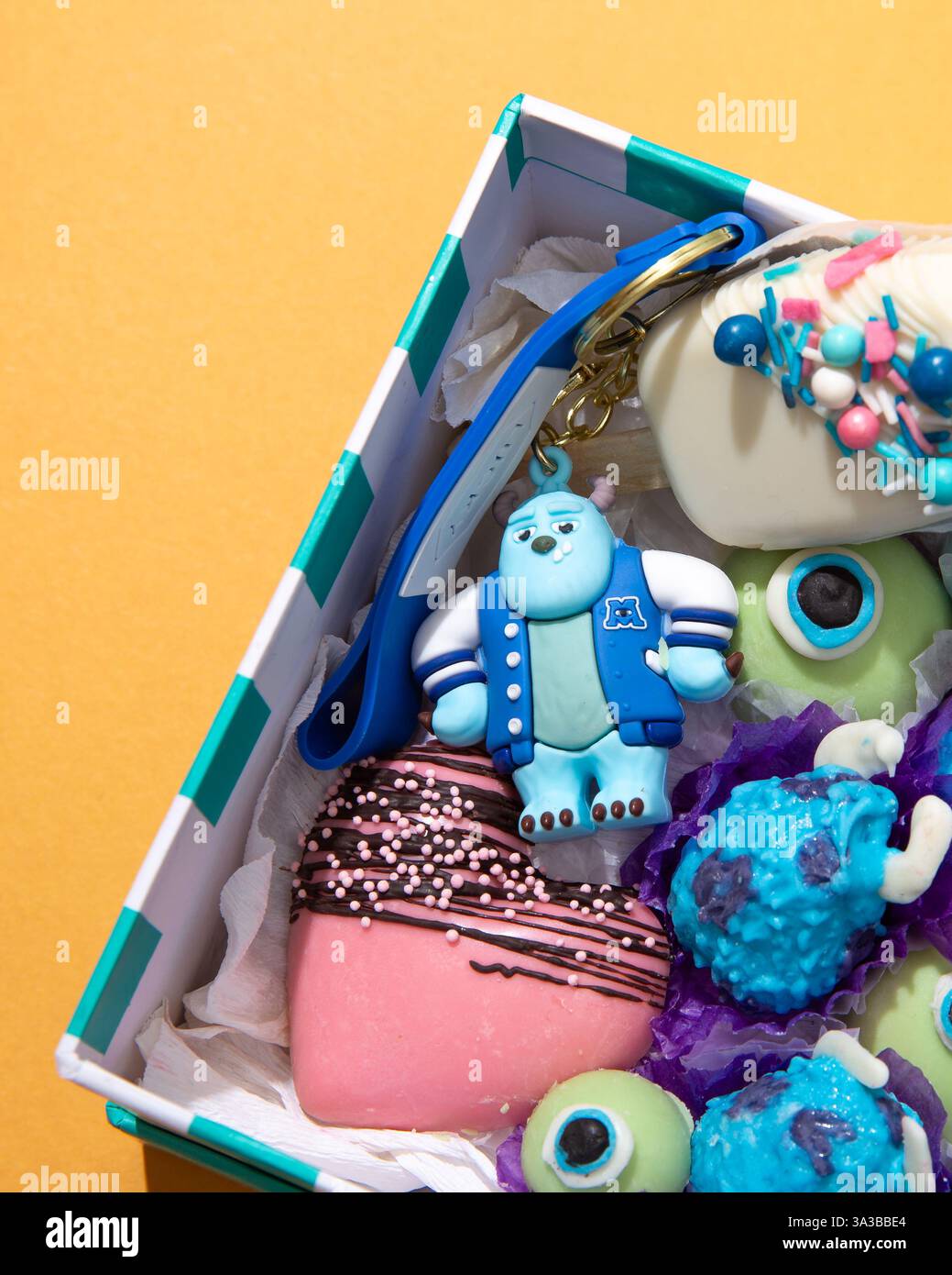 Primo piano di una stravagante confezione regalo piena di dolcetti a tema Monsters Inc. E portachiavi Sulley Foto Stock