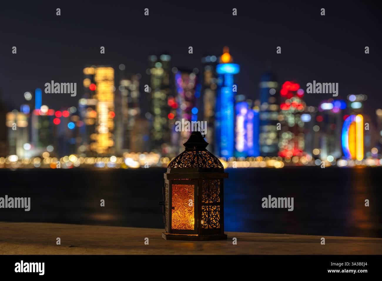 Lanterna con cielo crepuscolo e sfondo luminoso bokeh dello skyline di Doha per la festa musulmana del mese santo di Ramadan Kareem Foto Stock