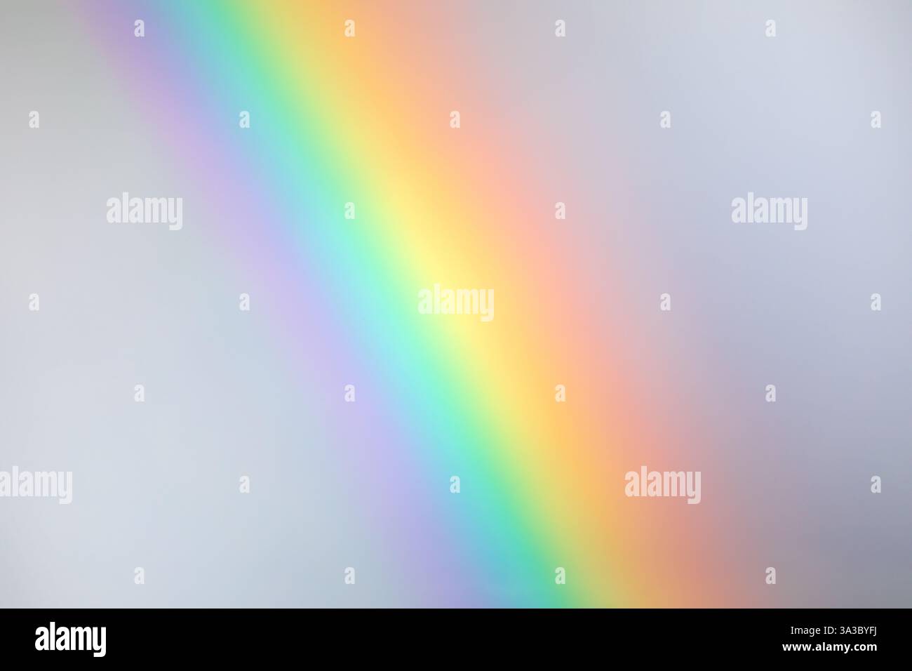 Dettaglio di un frammento arcobaleno con tutti i suoi colori su un cielo nuvoloso grigiastro con gradazioni perfette Foto Stock