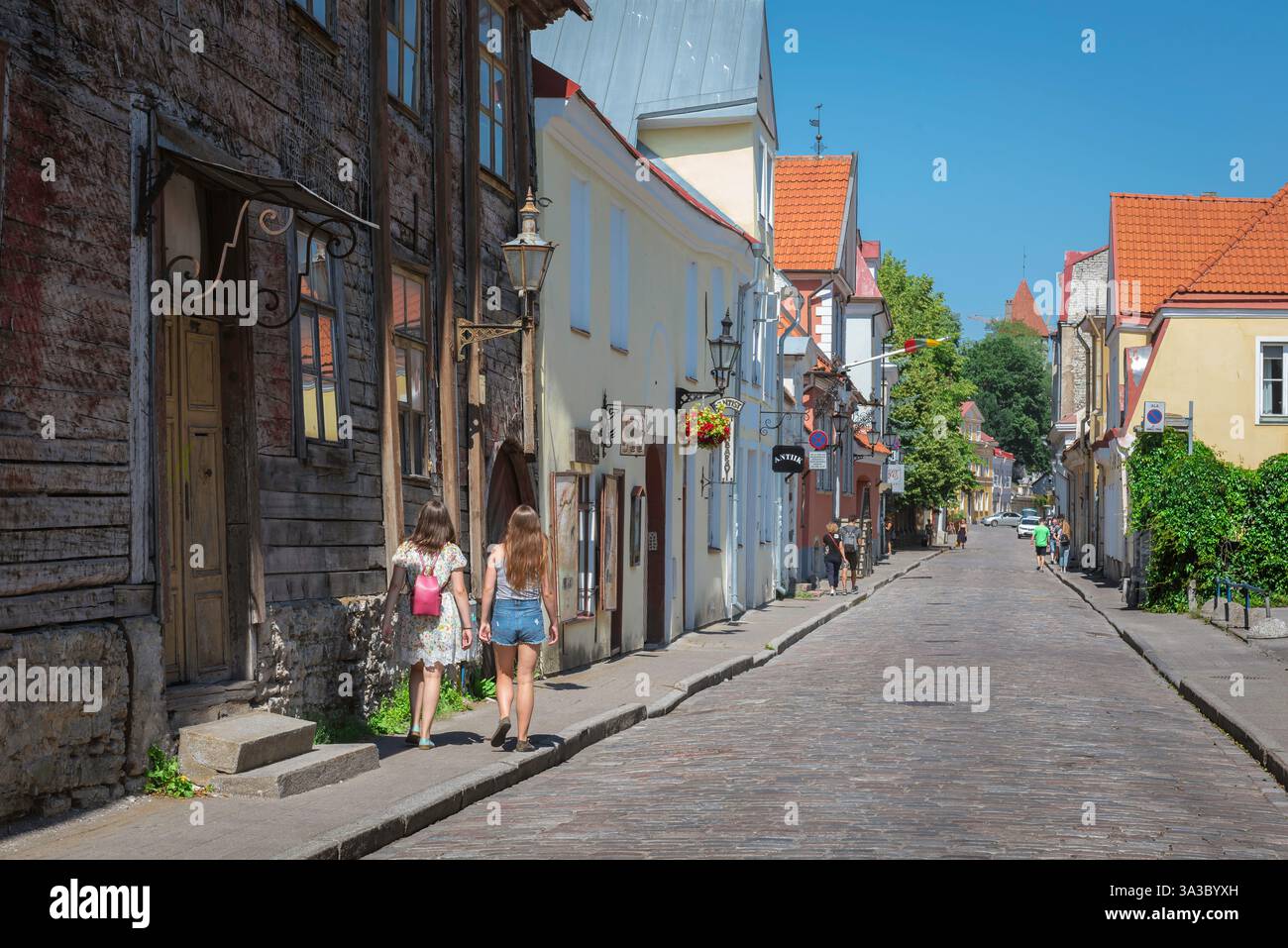 Città vecchia di Tallinn, vista in estate di due giovani turisti che esplorano una strada panoramica nella storica zona della città vecchia di Tallinn, Estonia. Foto Stock