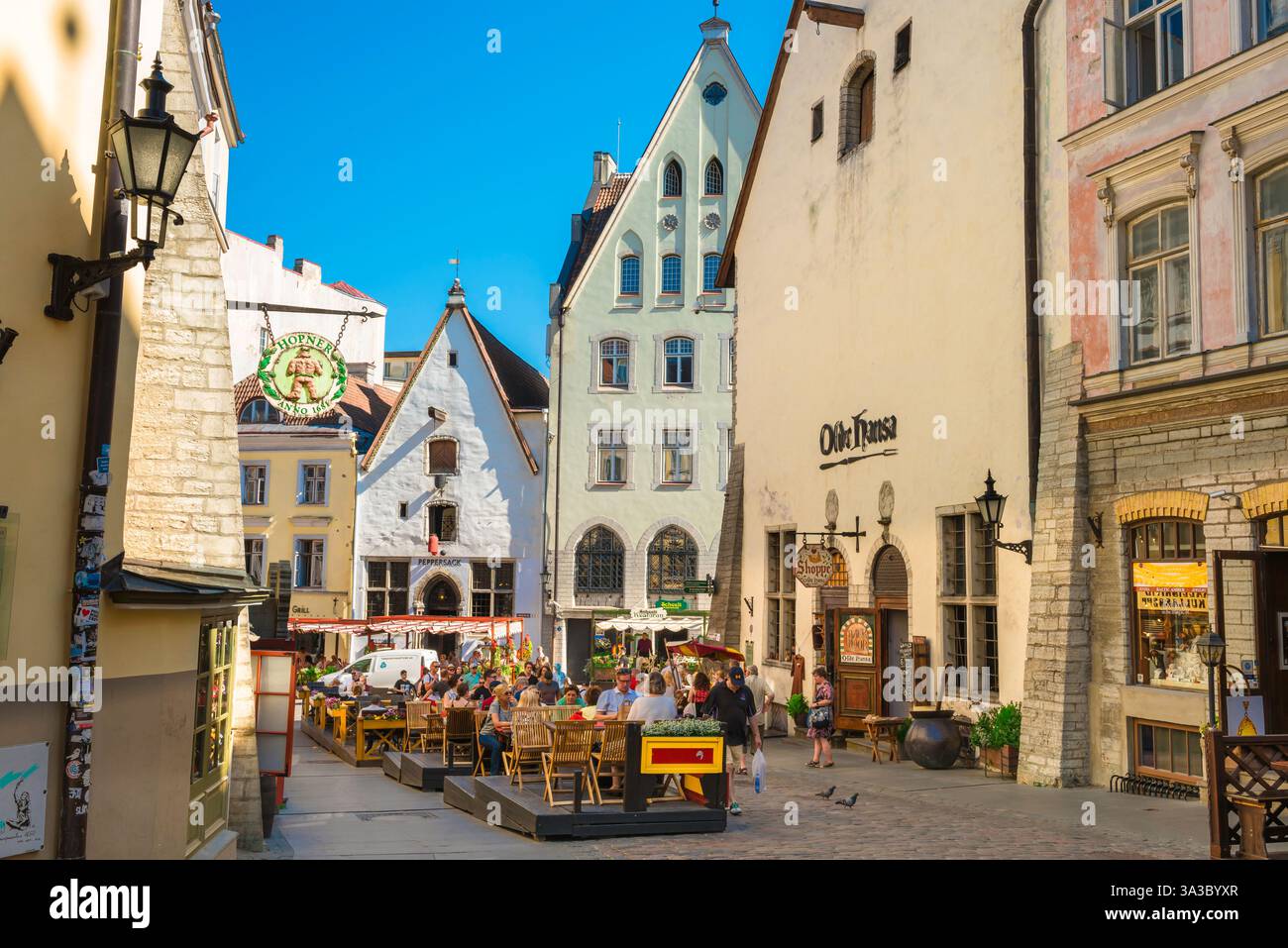 La città vecchia di Tallinn, in Estonia, vedrà le persone sedute ai tavoli da caffè in un pomeriggio estivo lungo Vanaturu kael nella medievale città vecchia di Tallinn, in Estonia Foto Stock