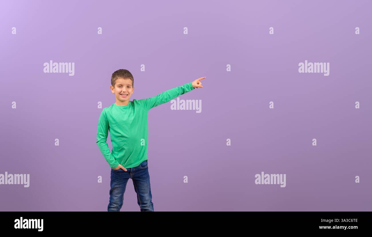 Ritratto di un giovane venditore che sorride e punta lo spazio di copia su sfondo viola Foto Stock