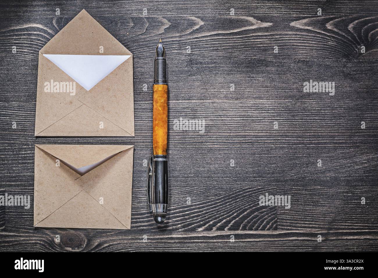 Penna stilografica con busta vintage su tavola di legno Foto Stock