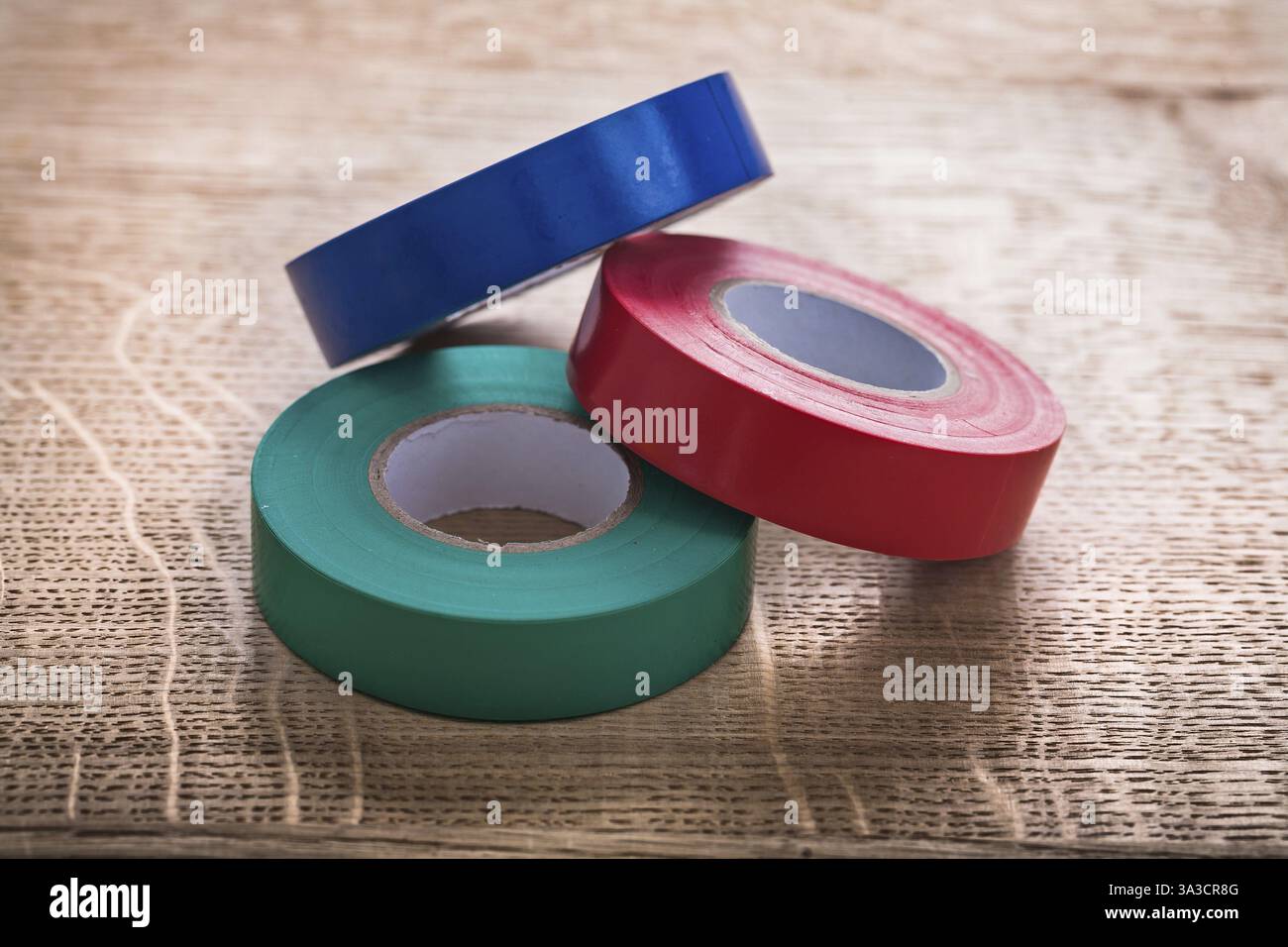 Tre rotoli di nastro isolante su pannelli di legno Foto Stock