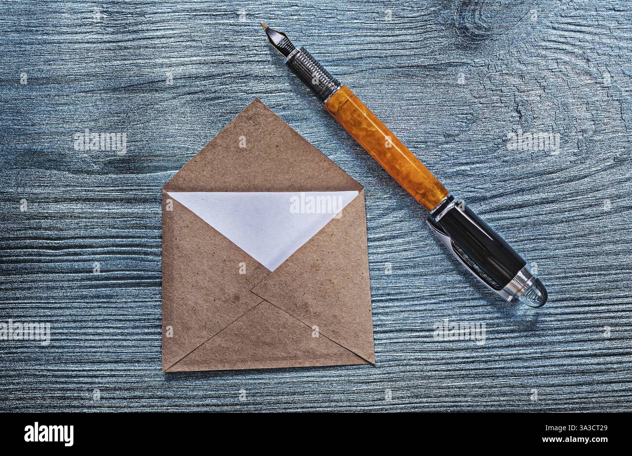 Busta aperta vintage con penna stilografica su tavola di legno Foto Stock