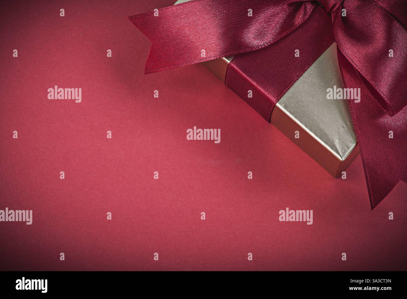 Confezione regalo confezionata su sfondo rosso per le festività Foto Stock