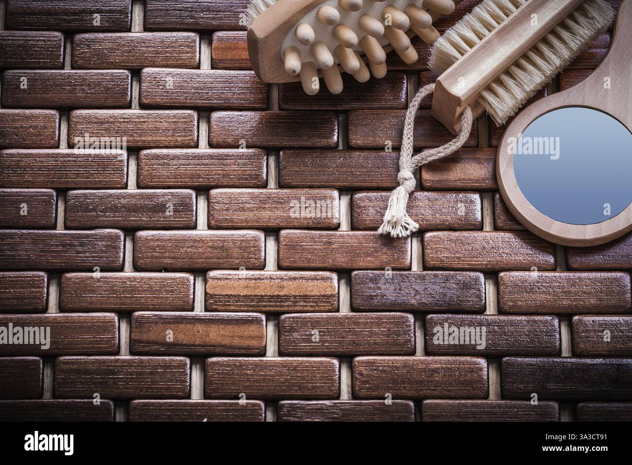 Massaggiatore in legno e spazzola per peeling sul concetto di sauna con tappetino in legno testurizzato Foto Stock