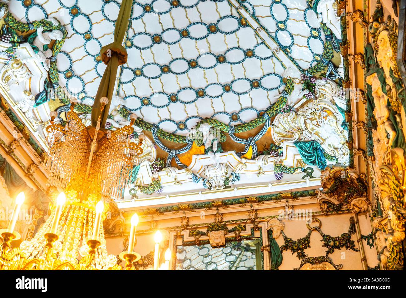 Un lampadario pende da un soffitto di vetro colorato delle camere Foto Stock