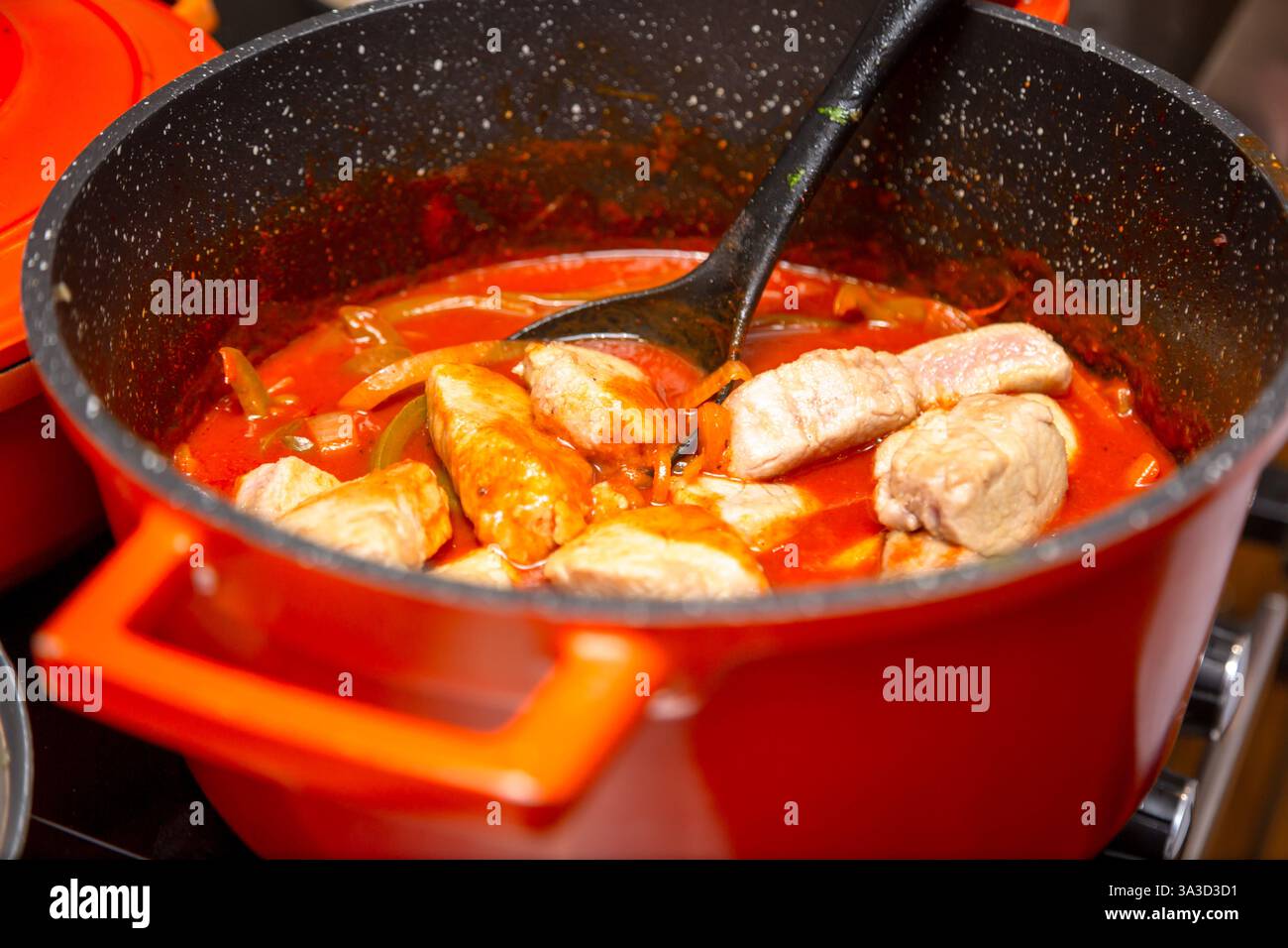 Pezzi di maiale in padella con salsa di pomodoro e pepe Foto Stock