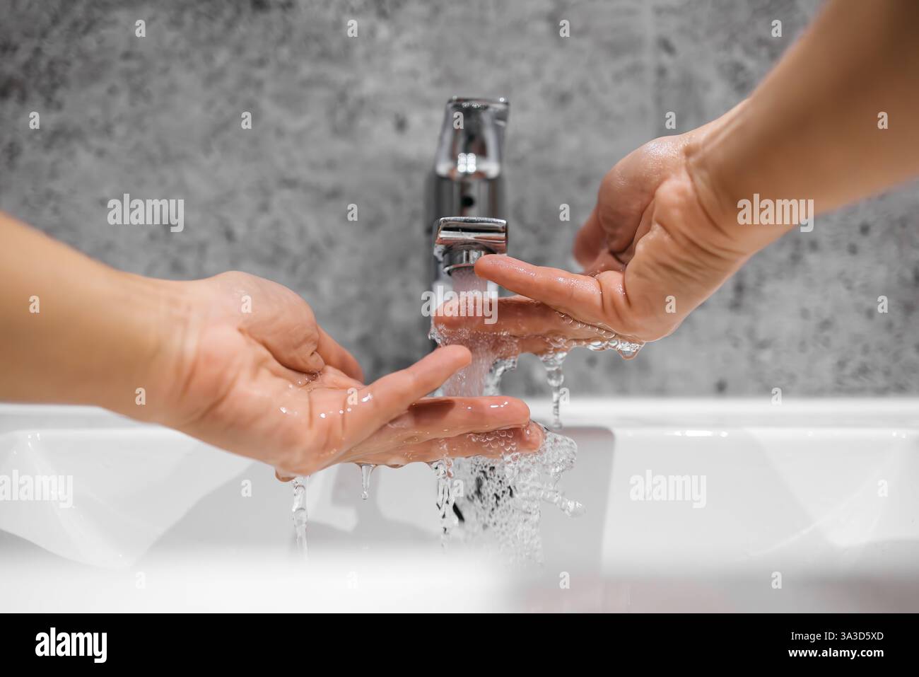 Primo piano del lavaggio delle mani sotto l'acqua corrente, simboleggiando l'uso sostenibile delle risorse naturali. Un concetto di acqua di rubinetto pulita, conservazione dell'acqua Foto Stock