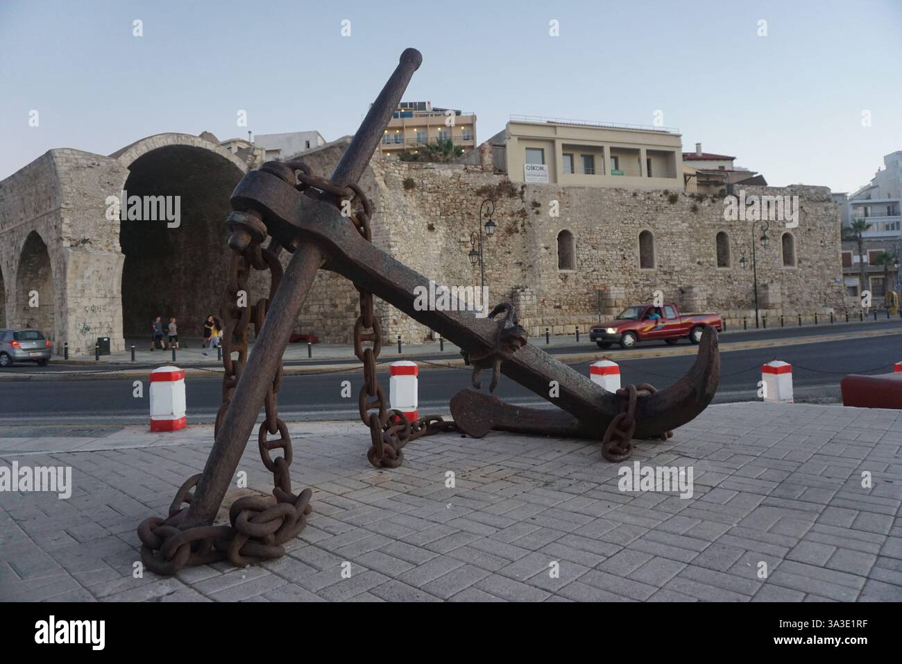 Un'enorme ancora e sullo sfondo i cantieri navali veneziani di Heraklion Foto Stock