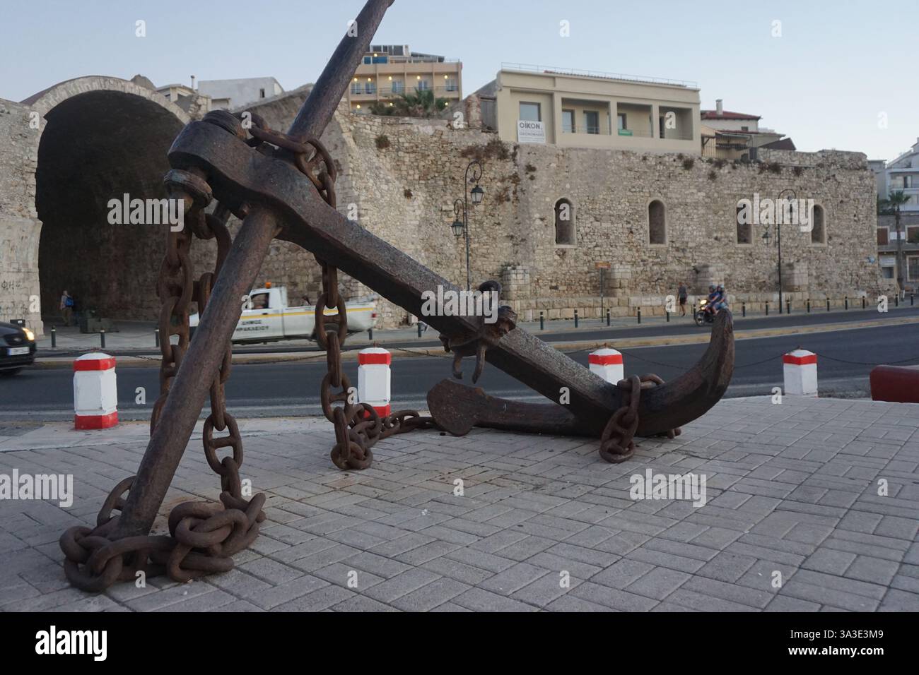 Un'enorme ancora e sullo sfondo i cantieri navali veneziani di Heraklion Foto Stock
