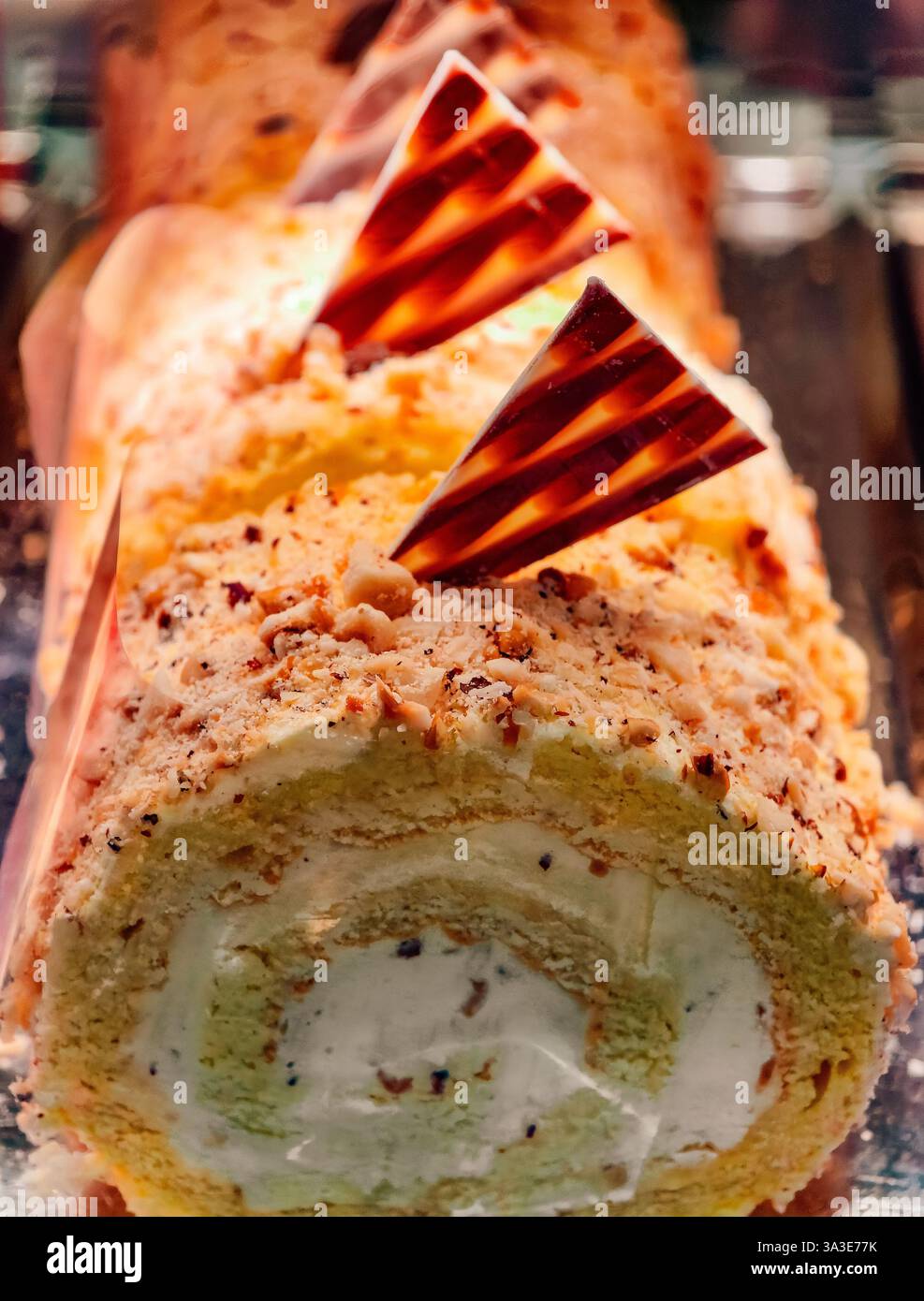 Deliziosa torta arrosto ripiena di panna con guarnizione di noci - rotolo svizzero gourmet per amanti dei dessert - perfetto per feste e dolci - elegante pasticceria dal sapore ricco e dalla consistenza Foto Stock