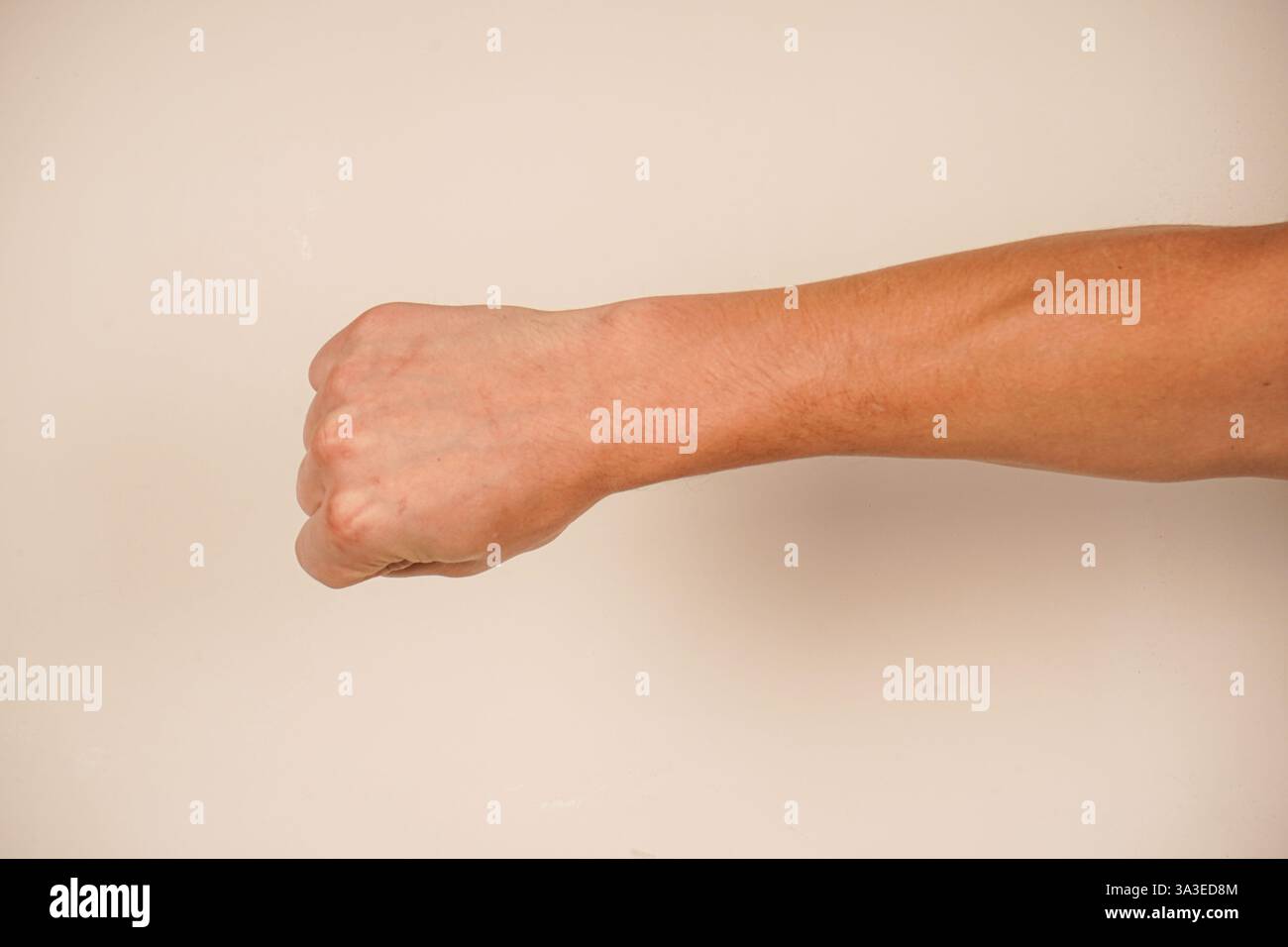 Questo gesto iconico parla di spirito combattivo. Lo sfondo semplice migliora la potenza della posa. Un simbolo senza tempo di coraggio. La mano forma un Foto Stock