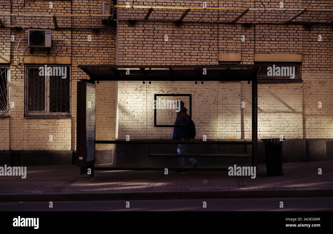 Kiev, Ucraina - 14 marzo 2025. Le persone sono viste navigare la loro routine quotidiana mentre aspettano i trasporti pubblici, catturando l'essenza della li urbana Foto Stock