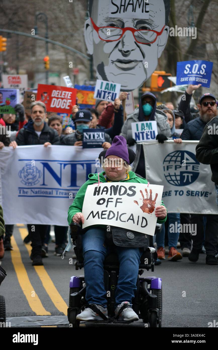 Persona su una sedia a rotelle che conduce una manifestazione Stop the Cuts contro i tagli DEL DOGE ai finanziamenti federali a Lower Manhattan. Foto Stock