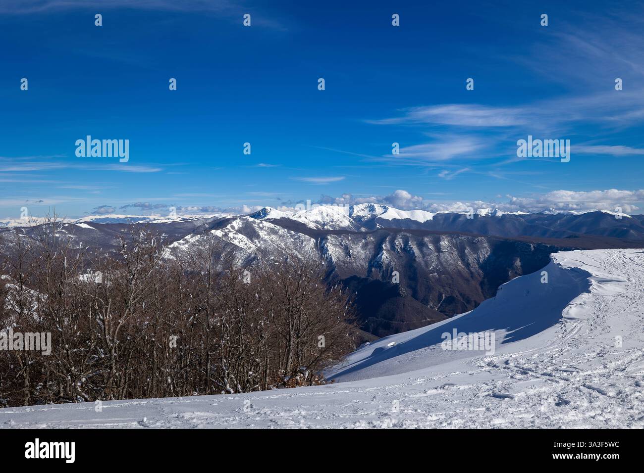 Sfondo naturale di un paesaggio montano invernale. Paesaggio di montagna innevato in una limpida giornata invernale, sullo sfondo la catena montuosa e il cielo blu. Sfondo naturale. Camerata nuova RM Italia Copyright: XGennaroxLeonardix Foto Stock