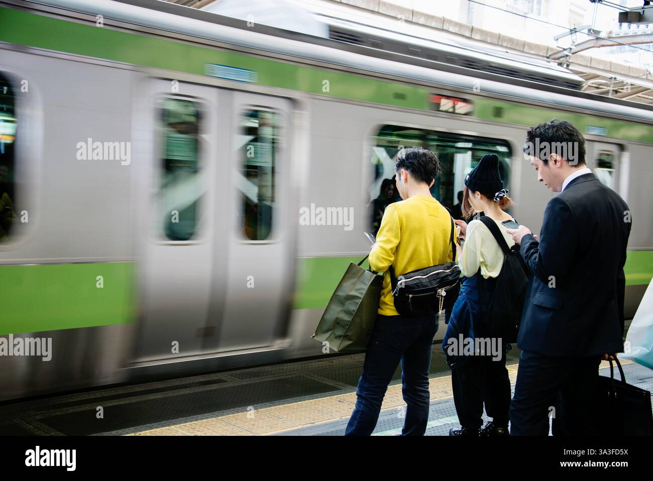 I passeggeri aspettano un treno della linea Yamanote alla stazione di Shinjuku a Tokyo, Giappone. Foto Stock