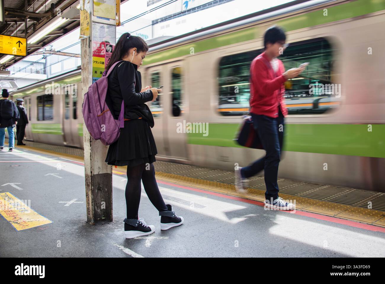 Un passeggero attende un treno della linea Yamanote alla stazione di Shinjuku a Tokyo, in Giappone. Foto Stock