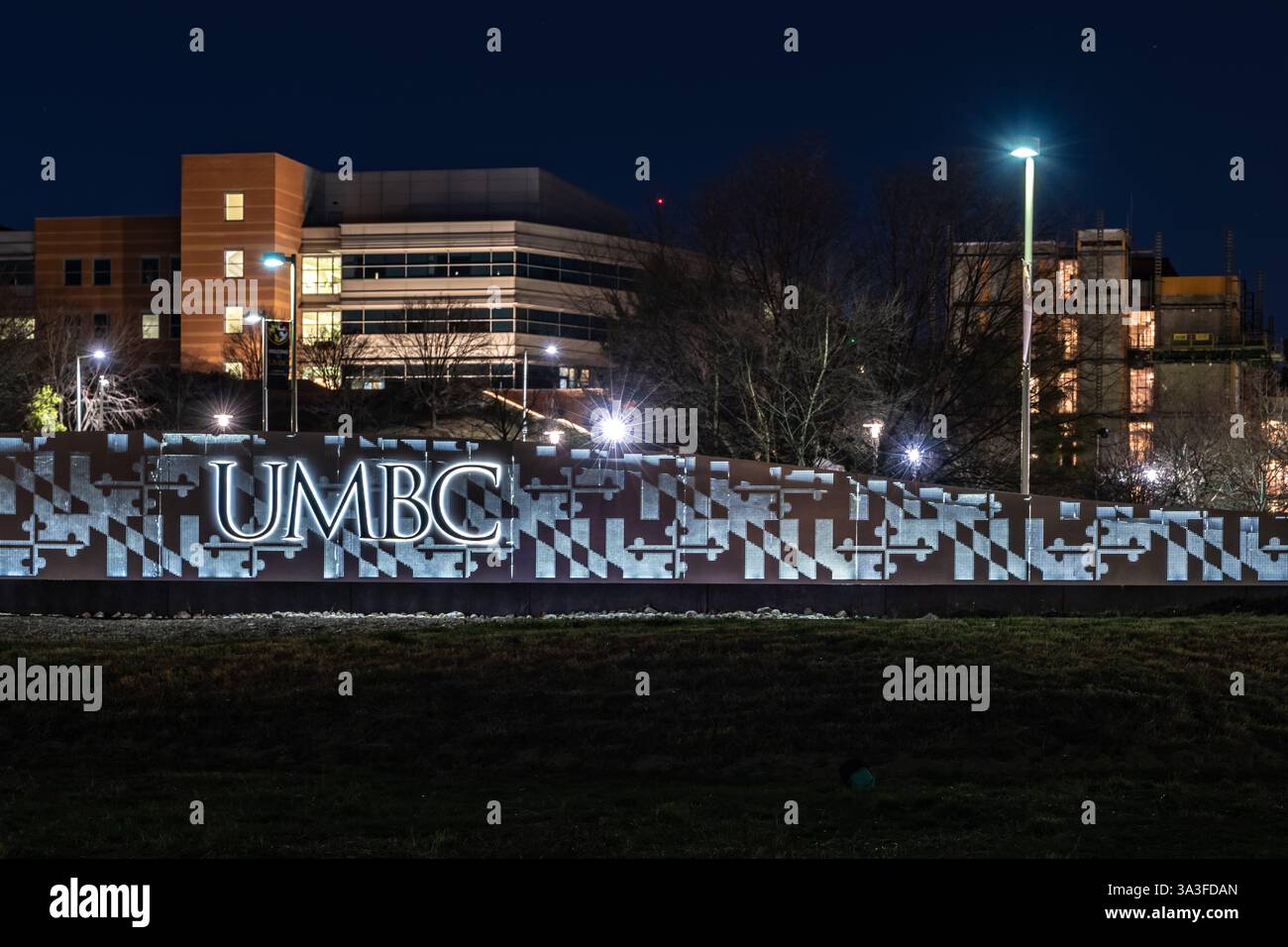 Baltimora, MD, USA - 8 marzo 2025: Foto notturna del cartello UMBC illuminato presso il campus della contea di Baltimora dell'Università del Maryland. Foto Stock