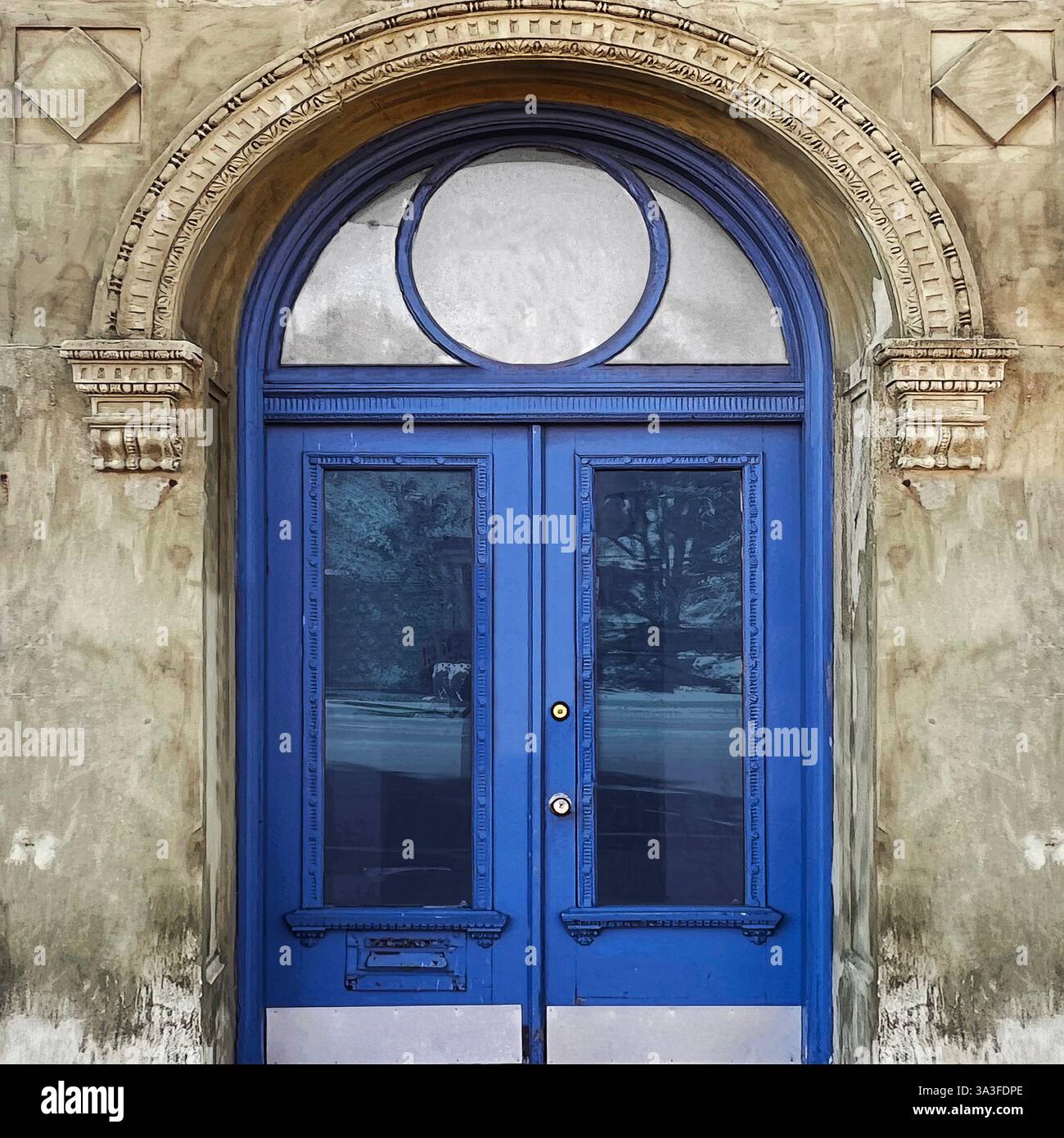 Elegante doppia porta ad arco blu con intricati dettagli architettonici adagiati in una storica facciata in pietra. - Immagine stock catturata con smartphone