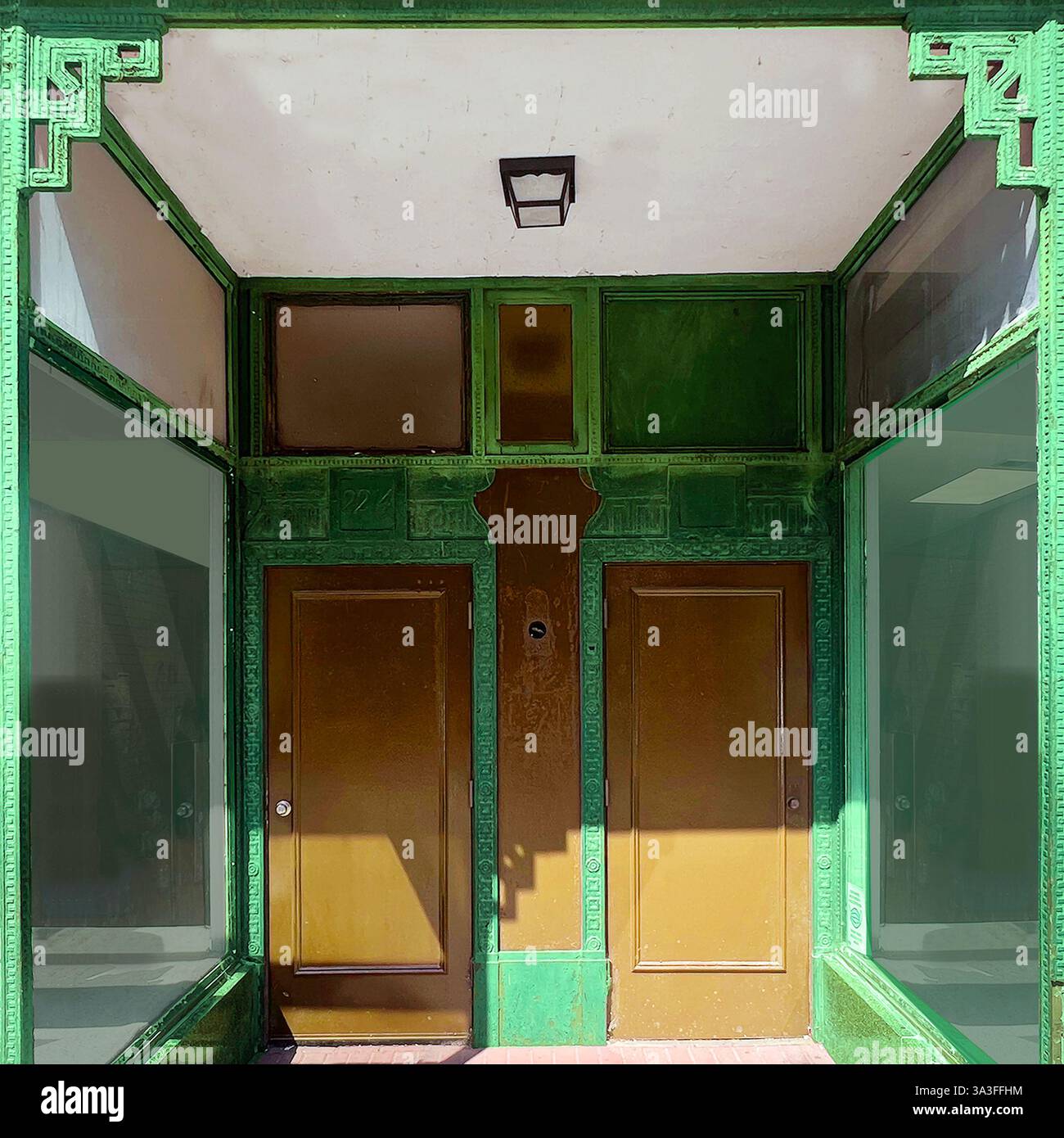 Uno storico ingresso di fronte al negozio nella Chinatown di Chicago, caratterizzato da intricati dettagli architettonici verdi e grandi finestre espositive. - Immagine stock catturata con smartphone