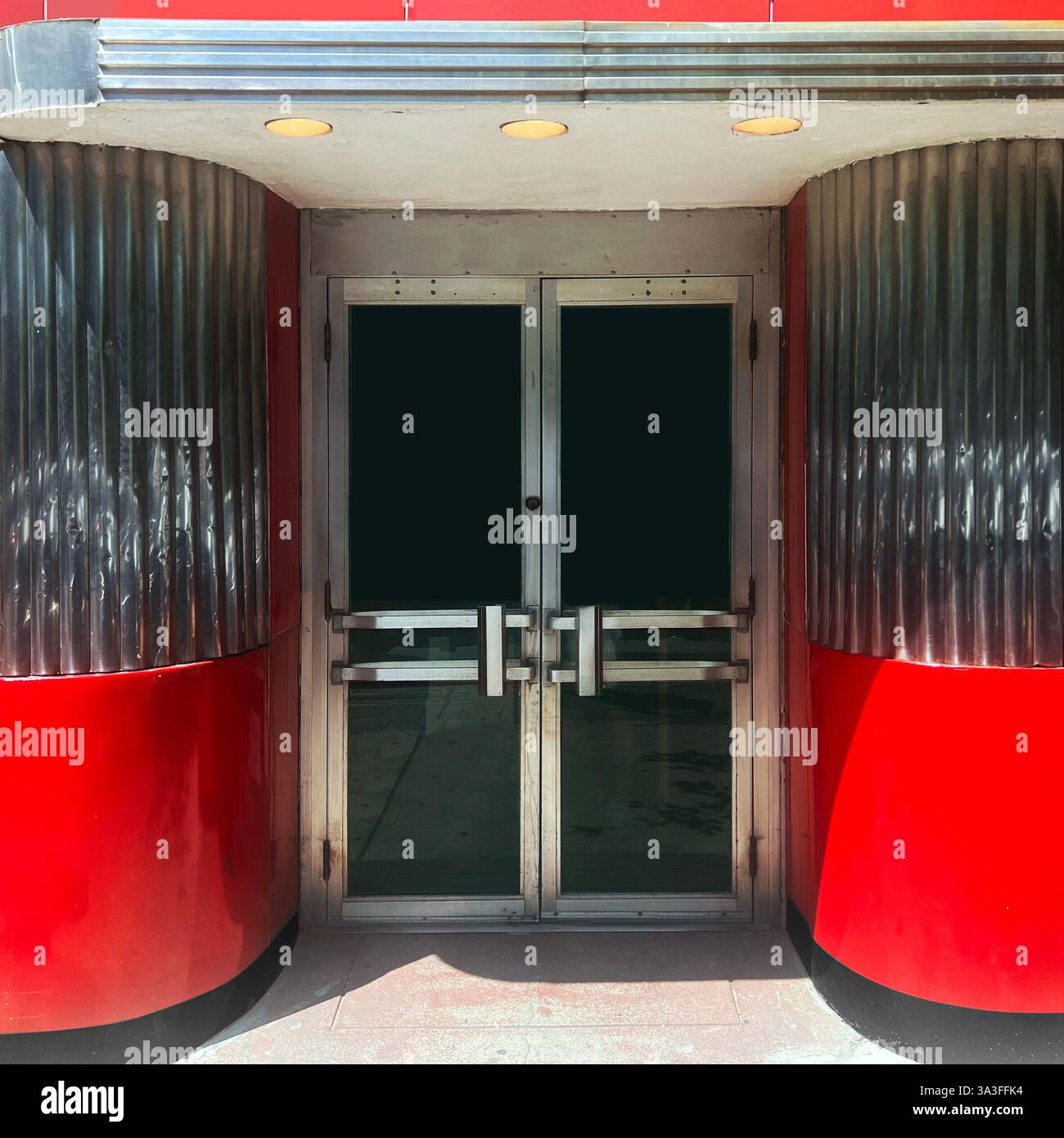 Un ingresso moderno essenziale a Chicago, caratterizzato da audaci dettagli rossi e cromati con eleganti dettagli metallici e un'estetica retrò. - Immagine stock catturata con smartphone