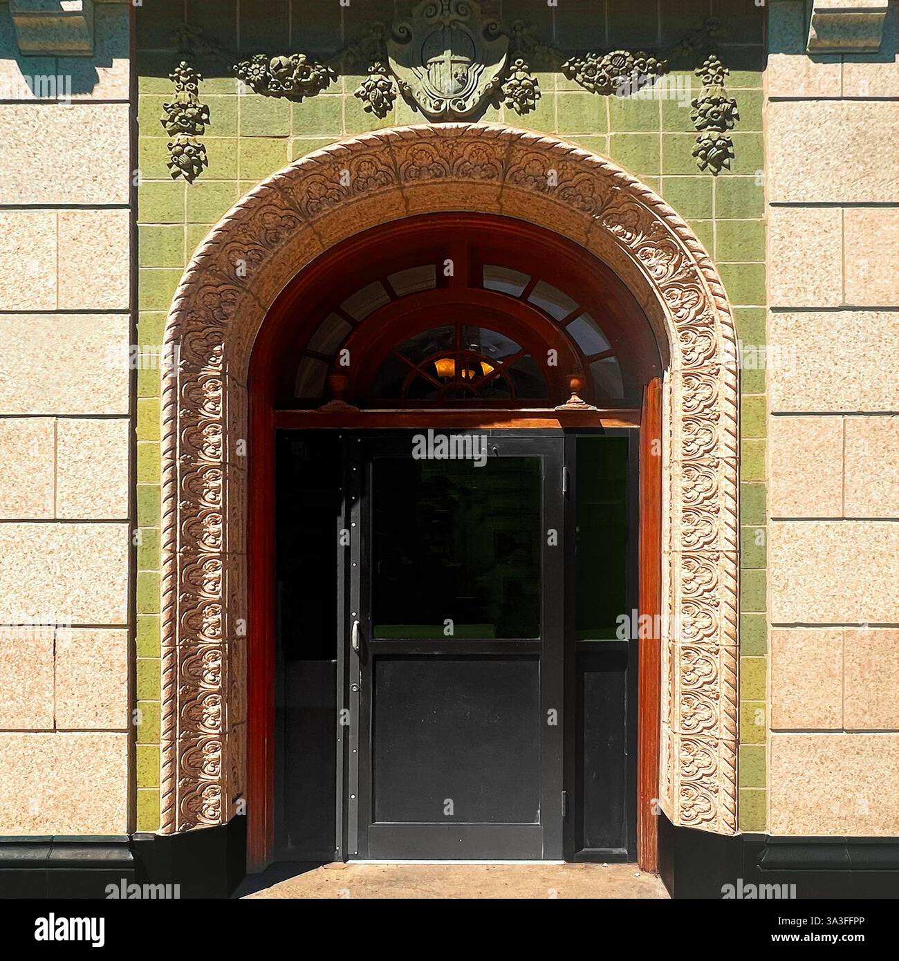 Un ingresso ornato ad arco con intricati dettagli in pietra si illumina sotto il sole pomeridiano a Chicago Foto Stock
