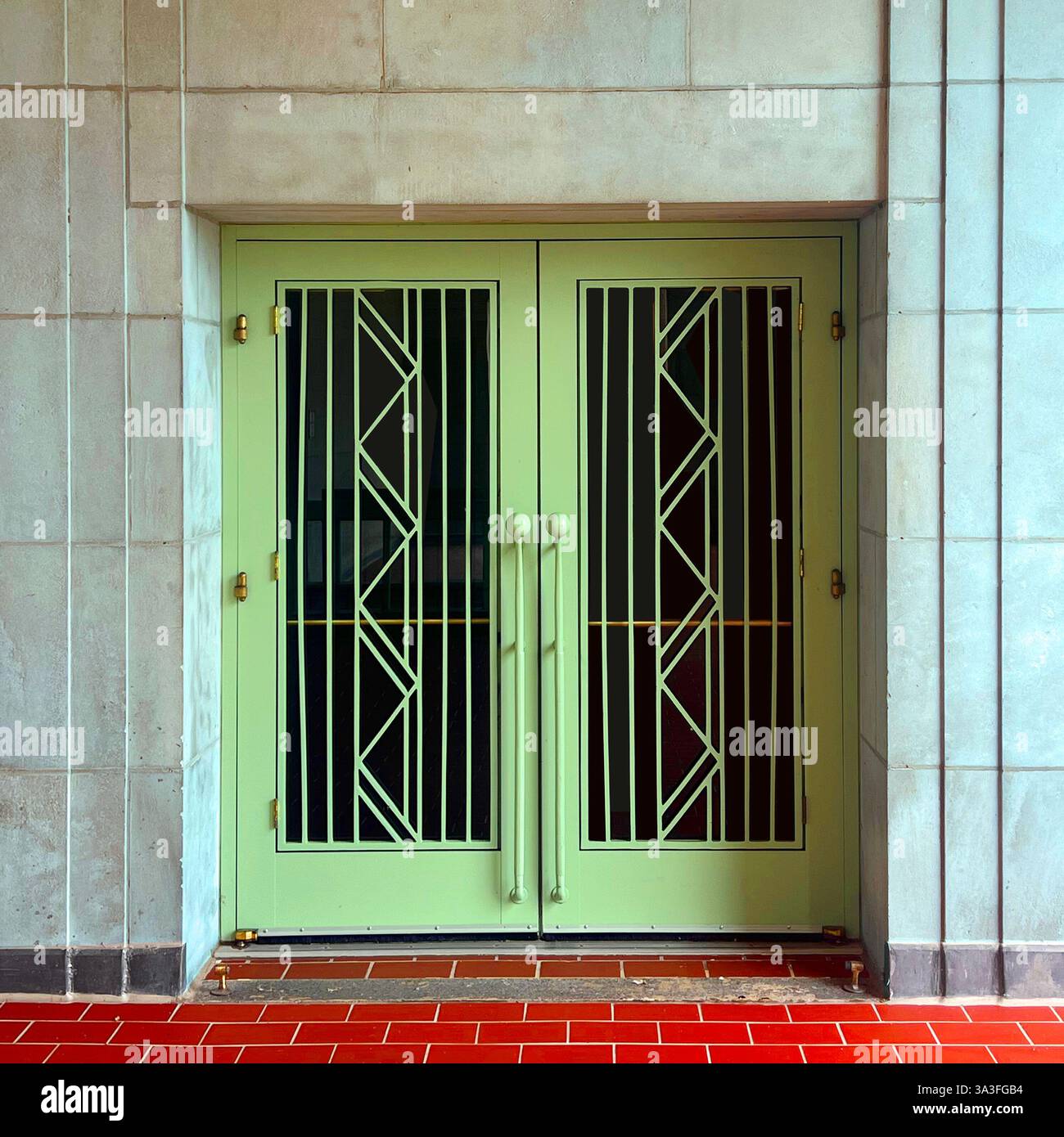 Porta verde menta Art Deco di Chicago con design geometrico in metallo e foor in piastrelle rosse. - Immagine stock catturata con smartphone