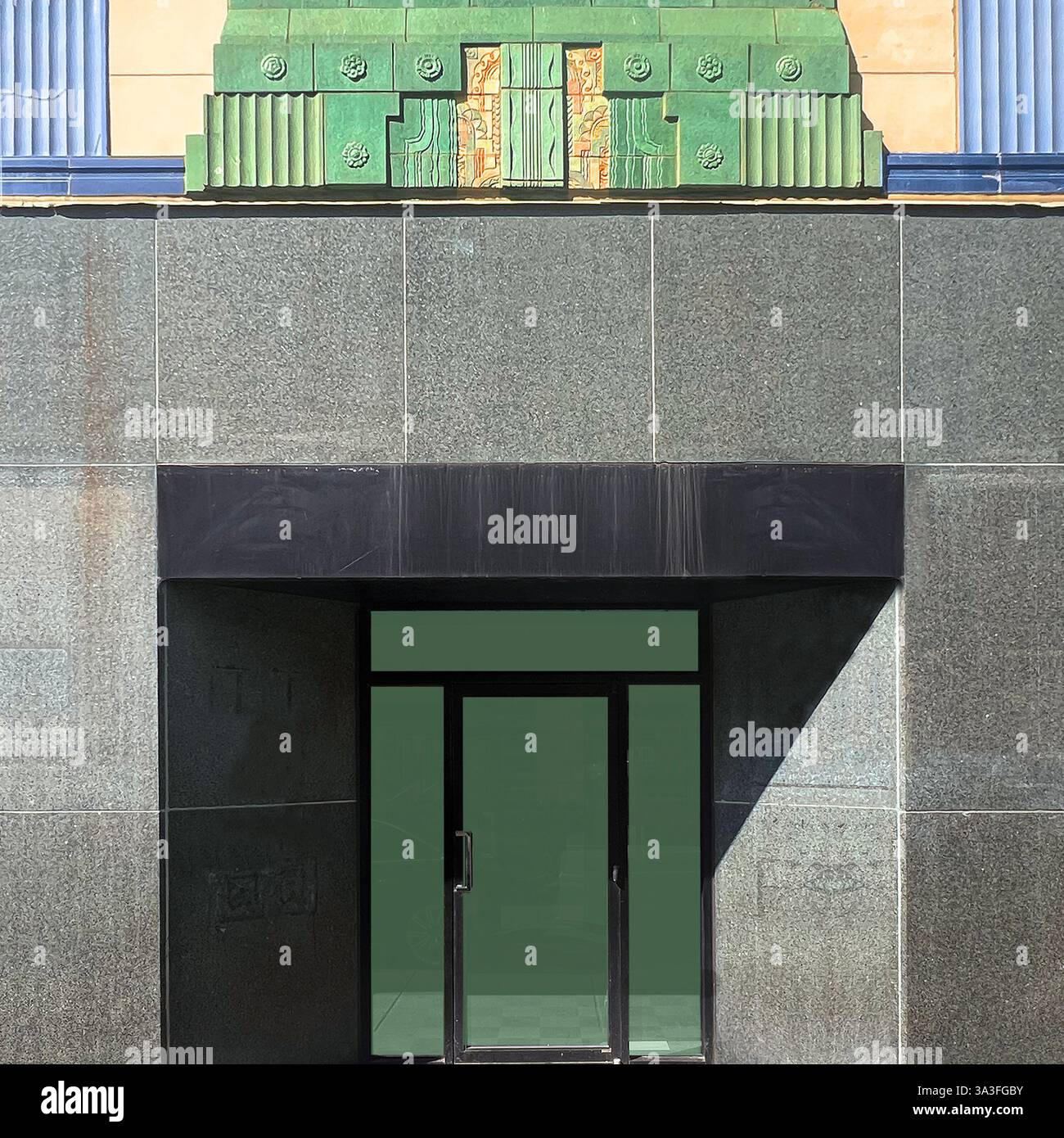 Ingresso Art Déco piastrelle di terracotta verde, intricati motivi geometrici, su una facciata vintage. - Immagine stock catturata con smartphone