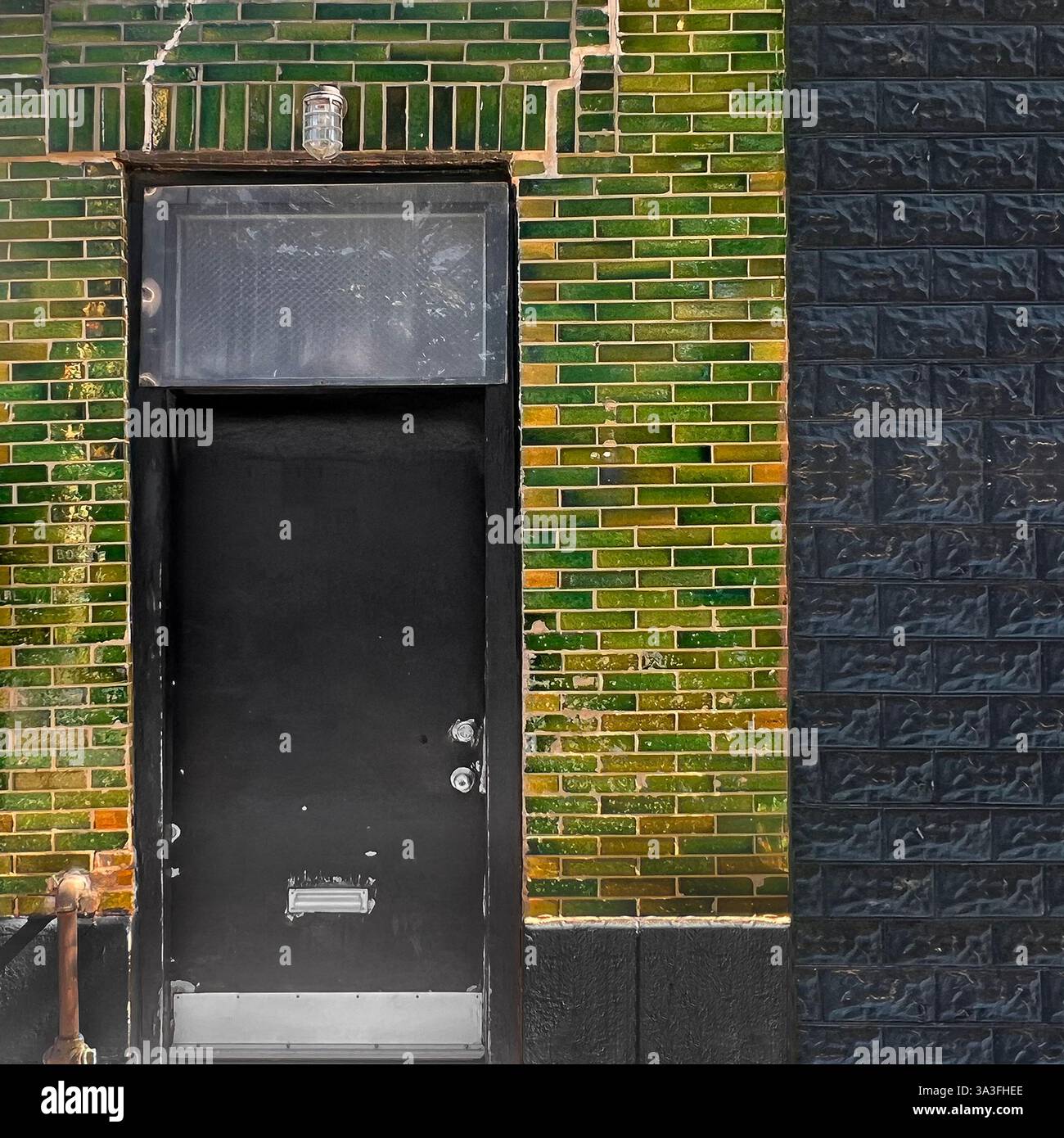 Ingresso circondato da una facciata in mattoni smaltati verdi a Chicago. Foto Stock