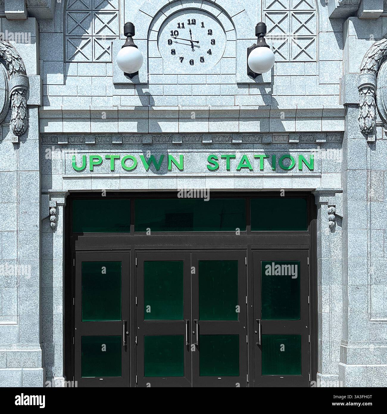 Il grande ingresso della Uptown Station di Chicago, caratterizzato da una facciata storica ornata, un orologio vintage e una suggestiva segnaletica verde. Foto Stock