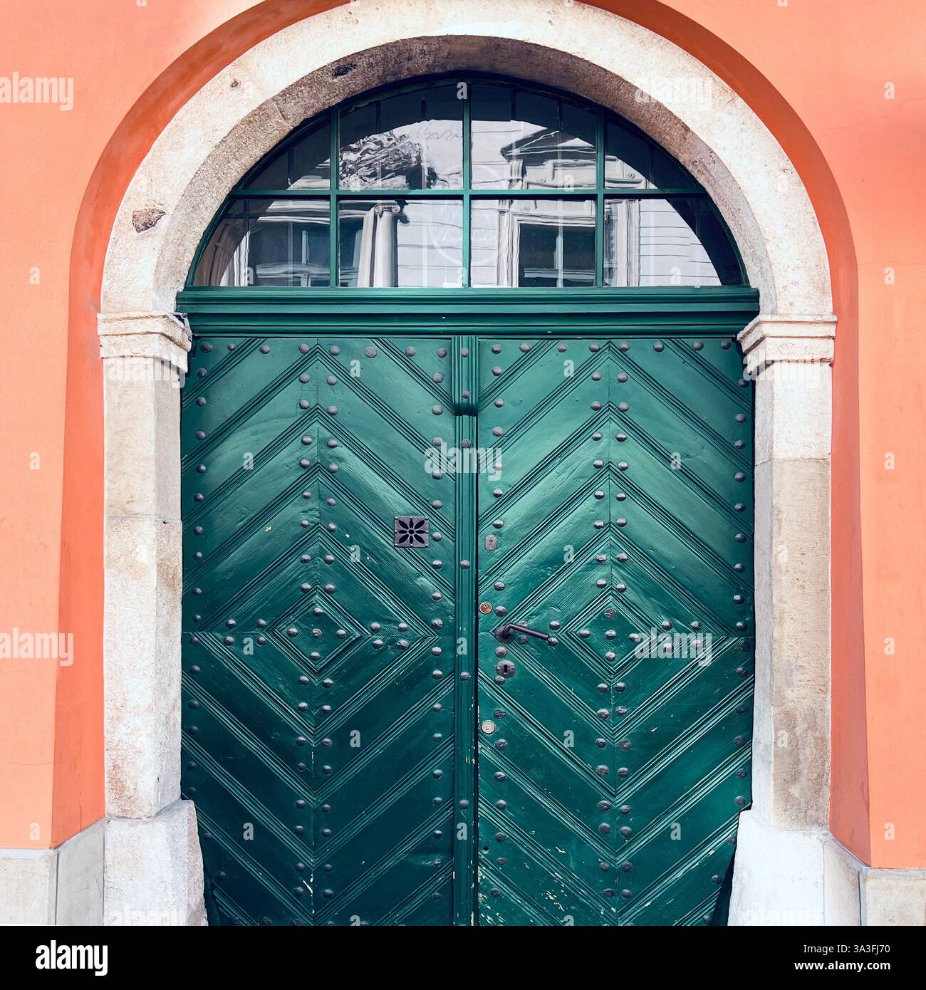 Elegante porta in legno ad arco verde scuro con borchie in ferro a Kraków, Polonia. Foto Stock