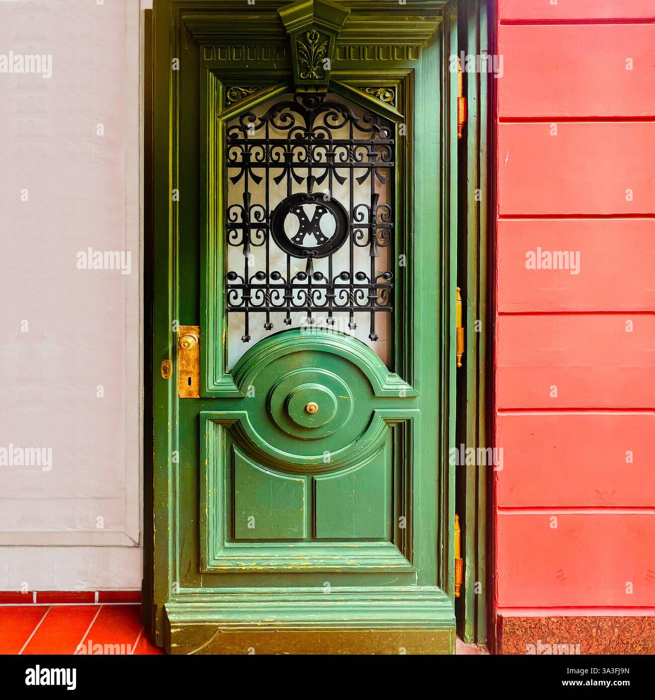 Una porta in legno verde ornata con intricati lavori in ferro e fascino vintage a Breslavia, Polonia. - Immagine stock catturata con smartphone