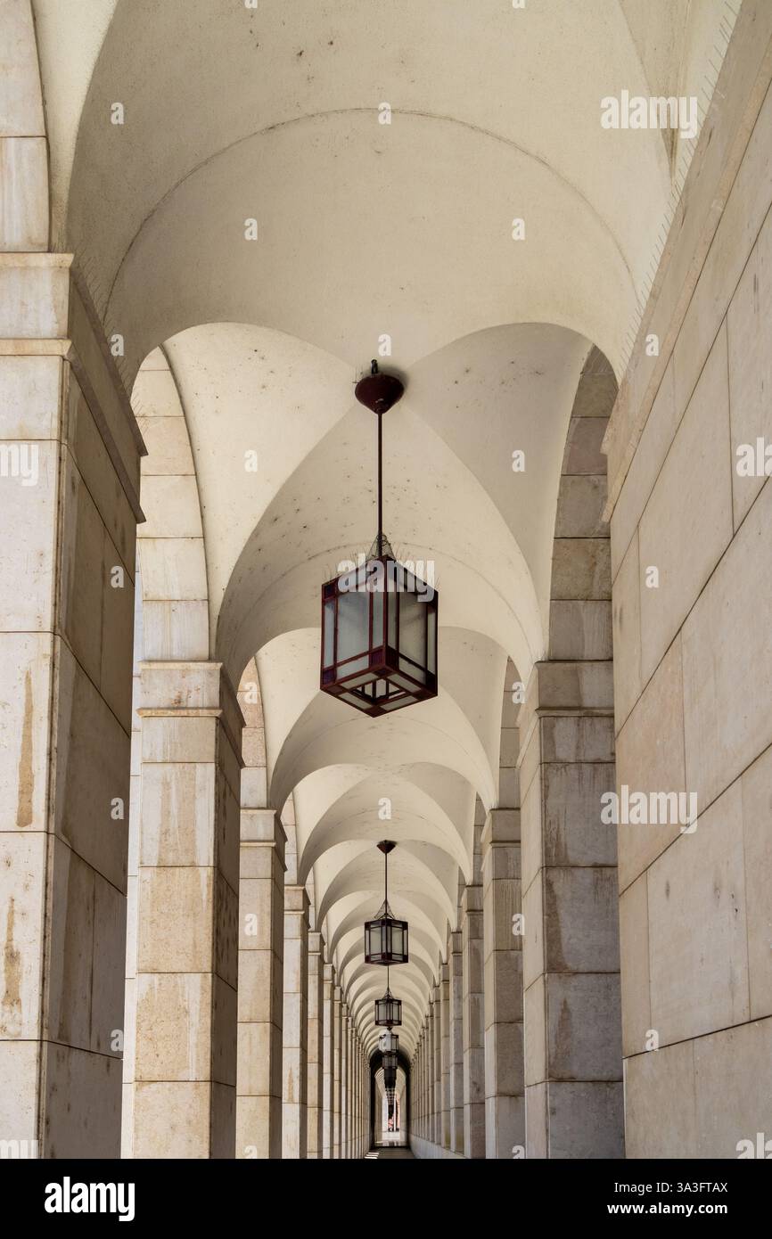 Vista simmetrica di un corridoio ad arco con lampade appese presso la sede centrale della caixa geral de depositos a lisbona, portogallo, creando un punto di scomparsa Foto Stock