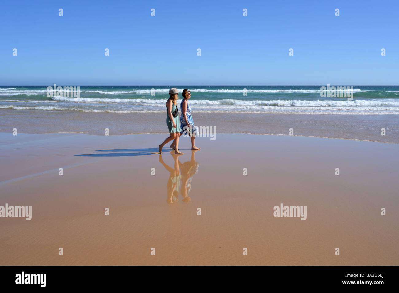 Passeggiando per la sabbia con la bassa marea, mamma e figlia si godranno un po' di benessere insieme a Surf Beach, Phillip Island (Australia) Foto Stock