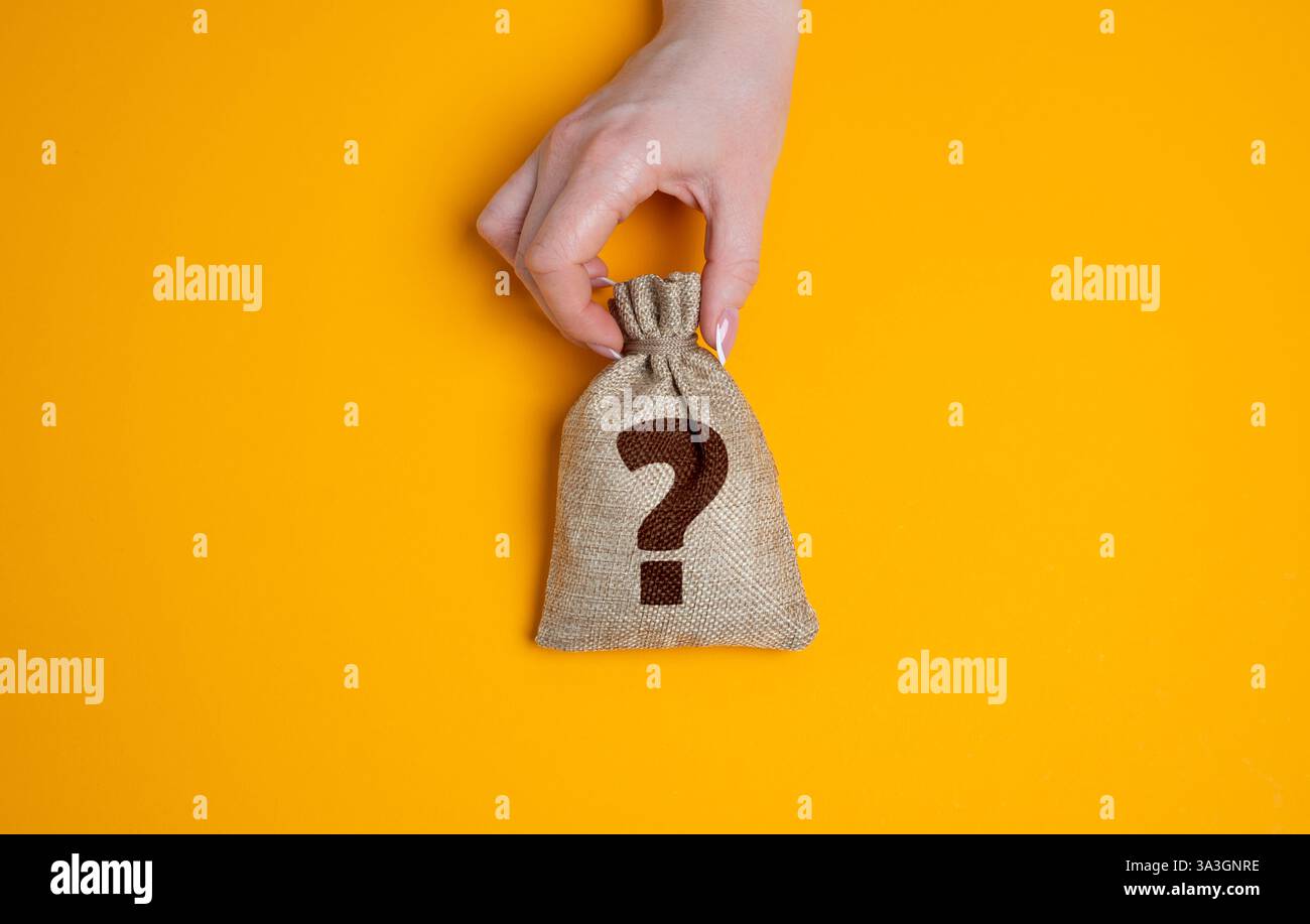 Mano che tiene in mano un sacchetto con un punto interrogativo. Incertezza finanziaria, ricchezza nascosta o risultati di investimento sconosciuti. Imprese rischiose, premi a sorpresa o Th Foto Stock